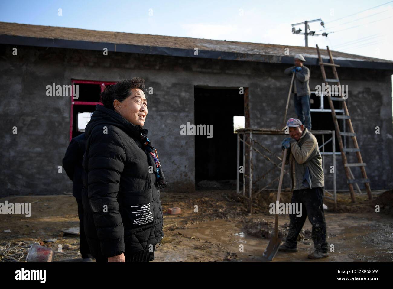 201225 -- YINCHUAN, 25 dicembre 2020 -- Ding Haiyan segue la costruzione di una mensa quasi pronta per gli anziani, l'ultima delle sue promesse agli abitanti del villaggio, nel villaggio di Hejiayuan di Xihaigu, nella regione autonoma Ningxia Hui della Cina nord-occidentale, 28 ottobre 2020. Xihaigu, una regione in gran parte montuosa nel nord-ovest di Ningxia, una volta fu inflitta dalla povertà profonda ed etichettata come il luogo più inadatto per l'insediamento umano da parte delle Nazioni Unite negli anni '1970 a causa della bonifica delle terre, della siccità e di un fragile ambiente ecologico. Il 16 novembre 2020, Xihaigu storicamente porge l'addio alla povertà assoluta, Foto Stock