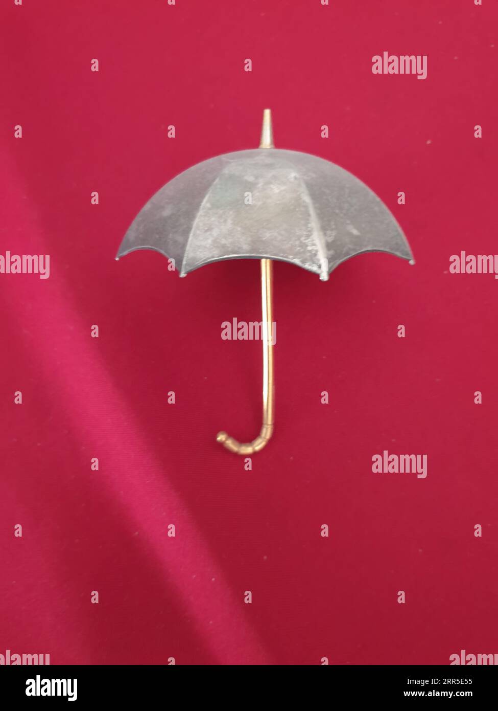Un ombrello aperto su sfondo rosso Foto Stock