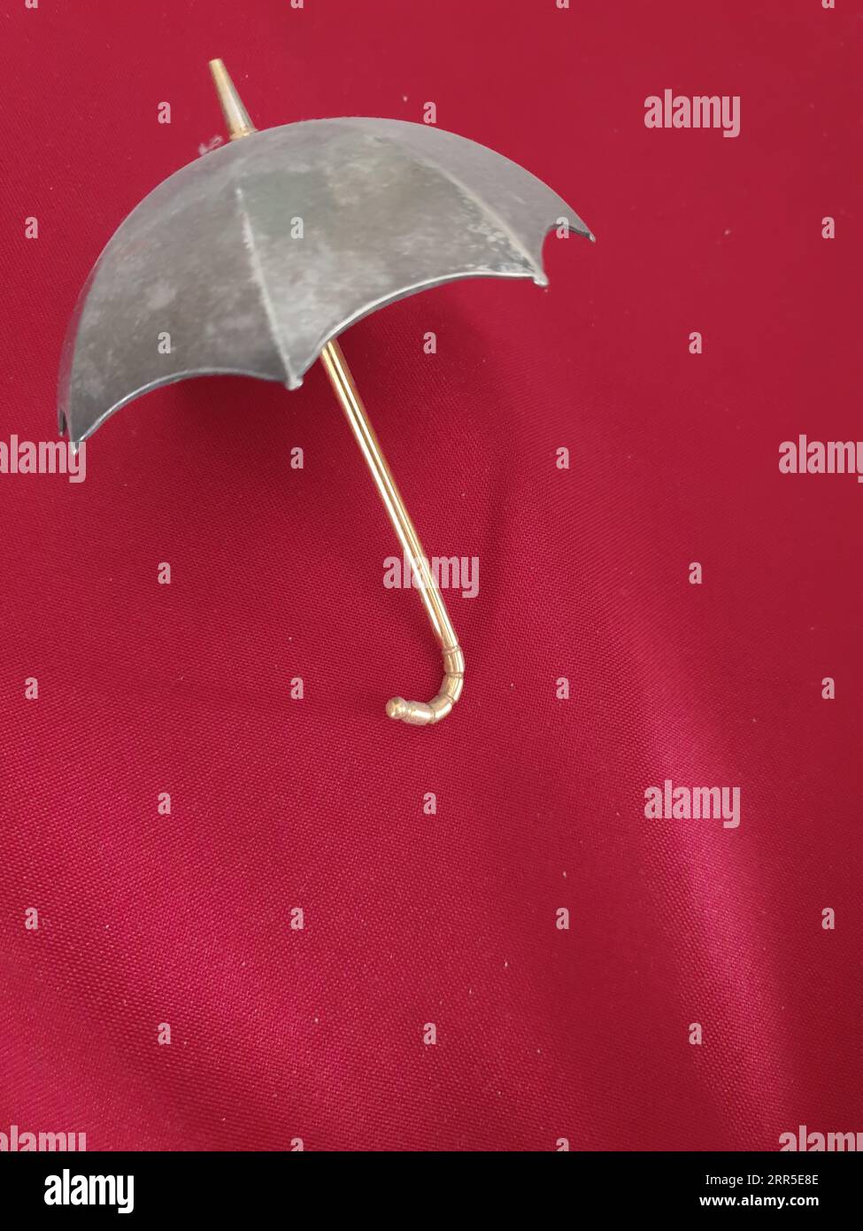 Un ombrello aperto su sfondo rosso Foto Stock