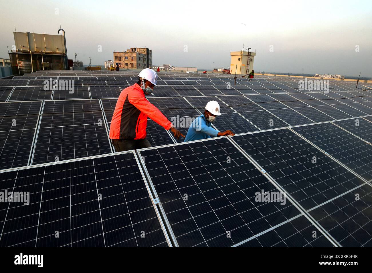 210104 -- GAZIPUR, 4 gennaio 2021 -- i supervisori controllano il processo di installazione dei pannelli solari in un edificio di fabbrica a Gazipur, alla periferia di Dacca, Bangladesh, il 3 gennaio 2021. Al giorno d'oggi i sistemi solari stanno diventando una forma sempre più popolare di energia alternativa in Bangladesh, e molte fabbriche del paese stanno passando a sistemi di energia solare. FABBRICA DEL BANGLADESH - ENERGIA SOLARE Salim PUBLICATIONxNOTxINxCHN Foto Stock