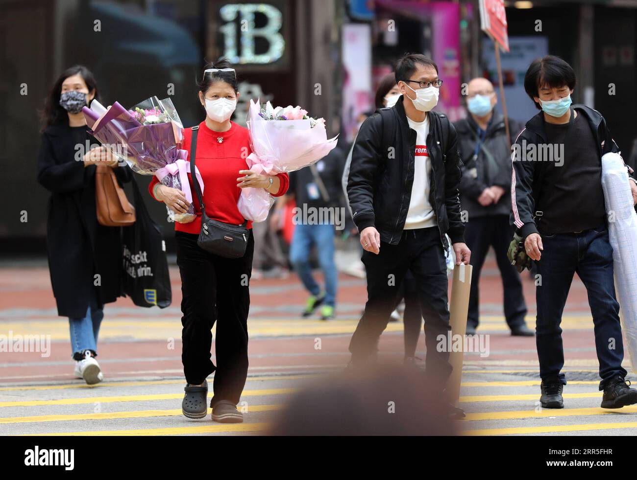 210105 -- HONG KONG, 5 gennaio 2021 -- le persone che indossano maschere facciali sono viste in una strada a Hong Kong, nel sud della Cina, 5 gennaio 2021. Il Centro per la protezione della salute di Hong Kong ha riportato 32 ulteriori casi confermati martedì, portando il totale a 9.049. La cifra giornaliera è scesa dalle 53 del lunedì e dalle 41 della domenica. CINA-HONG KONG-COVID-19-CASI CN WUXXIAOCHU PUBLICATIONXNOTXINXCHN Foto Stock