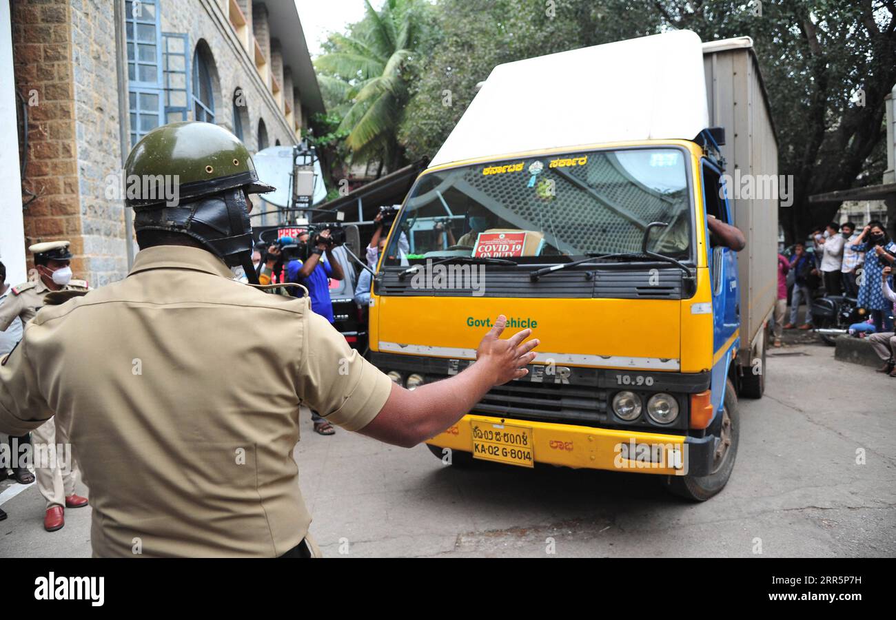 210112 -- BANGALORE, 12 gennaio 2021 -- i poliziotti sorvegliano l'ingresso del deposito frigorifero del Karnataka Health Department come un camion che trasporta fiale di vaccino Covishield sviluppato dal Serum Institute of India arriva a Bangalore, in India, 12 gennaio 2021. Il governo federale indiano ha detto che la campagna di vaccinazione contro la COVID-19 inizierà nel paese il 16 gennaio. Str/ INDIA-BANGALORE-COVID-19 VACCINO-ARRIVO Xinhua PUBLICATIONxNOTxINxCHN Foto Stock