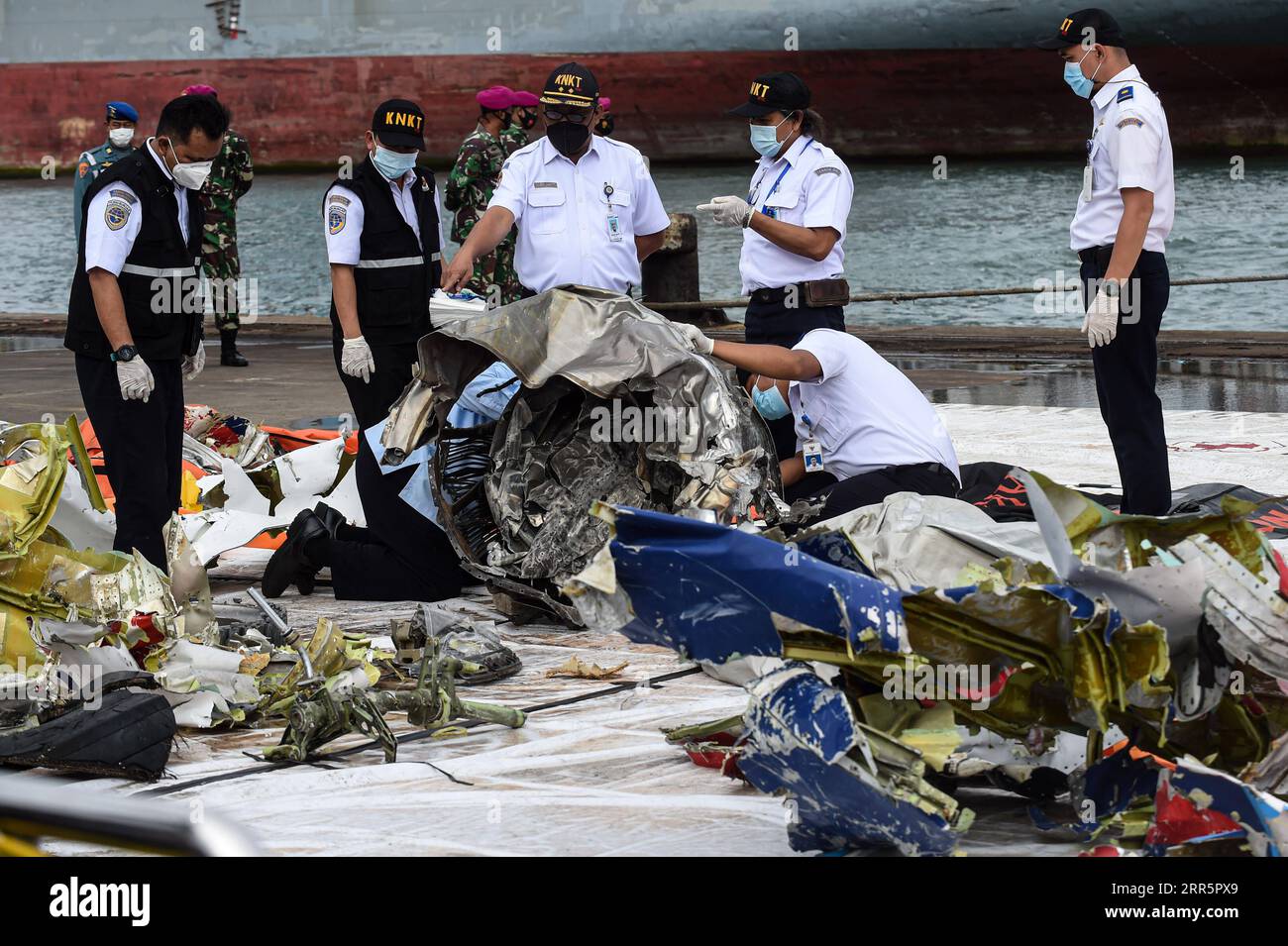 210113 -- GIACARTA, 13 gennaio 2021 -- il Comitato nazionale per la sicurezza dei trasporti ufficiali del KNKT controllano i detriti del volo Sriwijaya Air SJ-182 al porto di Tanjung Priok, Giacarta, Indonesia, 13 gennaio 2021. Martedì i sommozzatori hanno recuperato un registratore di dati di volo FDR, noto anche come scatola nera, dell'aereo Boeing 737-500 Sriwijaya Air che è precipitato in acqua al largo della costa della capitale indonesiana Giacarta sabato, ha detto qui il comandante militare indonesiano, il capo dell'aviazione, il Marshall Hadi Tjahjanto. INDONESIA-GIACARTA-AEREO-CRASH-SEARCH AGUNGXKUNCAHYAXB. PUBLICATIONxNOTxINxCHN Foto Stock