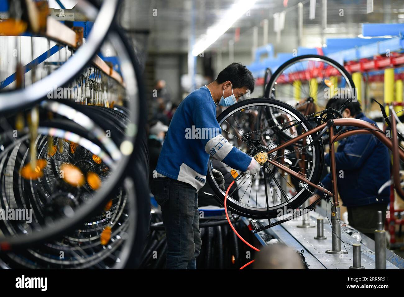 210114 -- TIANJIN, 14 gennaio 2021 -- i lavoratori assemblano parti di biciclette in una fabbrica nel distretto di Wuqing nel nord della Cina a Tianjin, 13 gennaio 2021. Wuqing è un centro di produzione e distribuzione di biciclette nel nord della Cina. Tianjin Golden Wheel Group, un'azienda leader nel settore delle biciclette fondata nel 1987, ha una capacità produttiva annuale di circa 80.000 e-bike e 2 milioni di biciclette, e i prodotti vengono esportati in oltre 120 paesi e regioni in tutto il mondo. Foto di /Xinhua CHINA-TIANJIN-ECONOMY-BICYCLE CN SunxFanyue PUBLICATIONxNOTxINxCHN Foto Stock