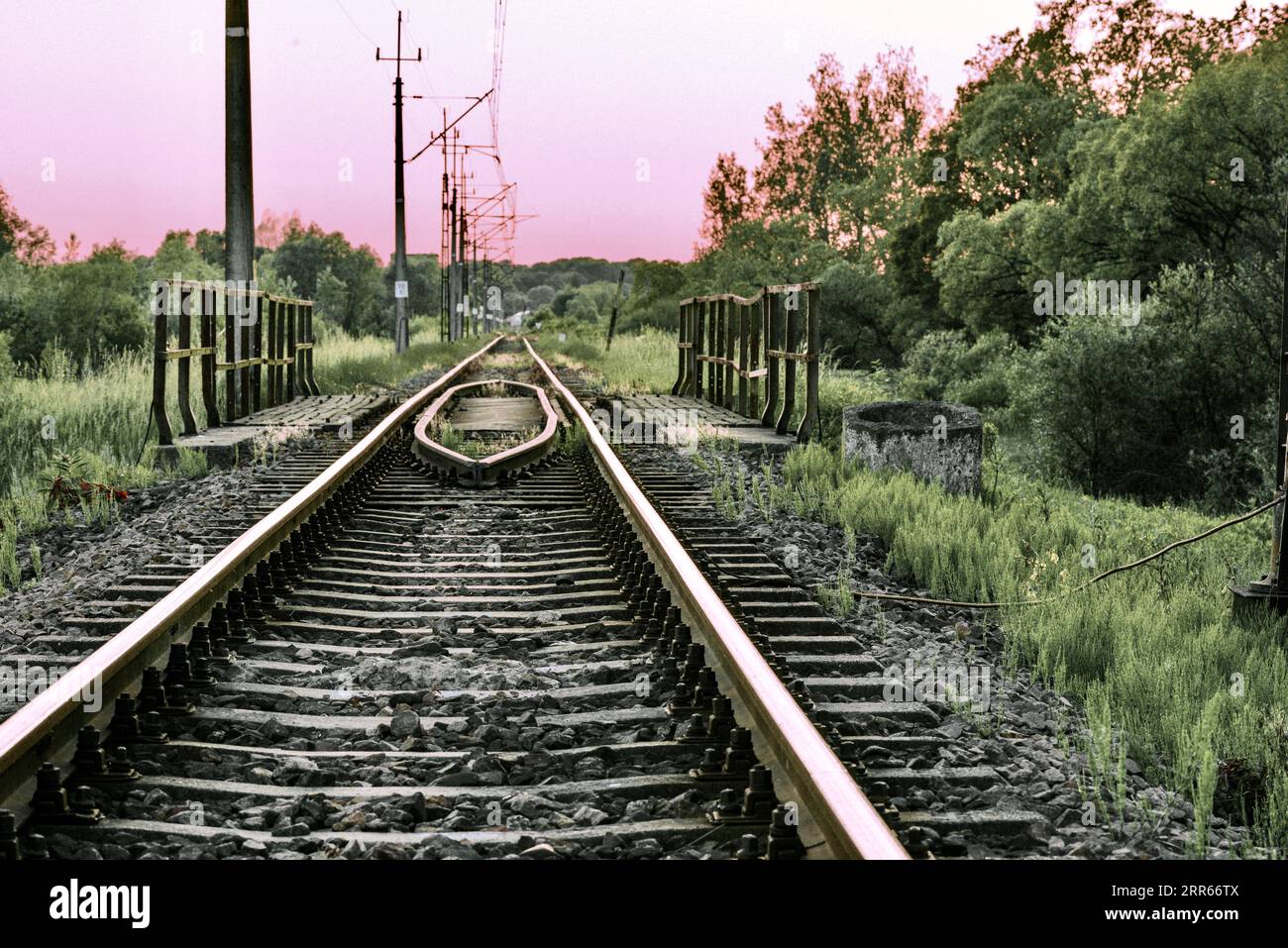 Binari ferroviari e rotaie nella campagna sullo sfondo di uno splendido tramonto. Foto Stock