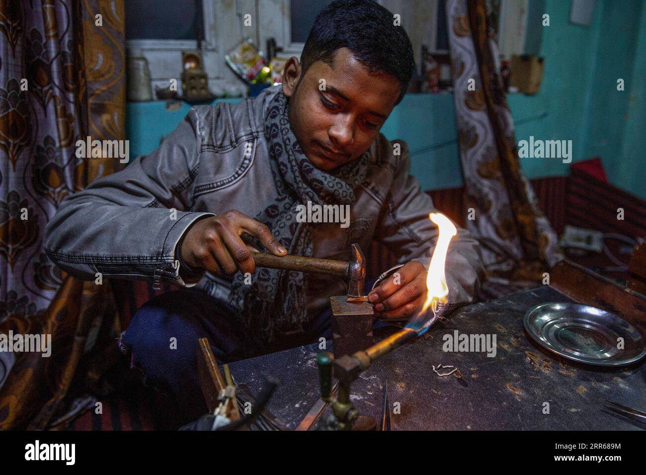 210131 -- SRINAGAR, 31 gennaio 2021 -- un artigiano lavora su un pezzo di gioielleria in un laboratorio a Srinagar, la capitale estiva del Kashmir controllato dagli indiani, 30 gennaio 2021. KASHMIR-SRINAGAR-GIOIELLERIA JavedxDar PUBLICATIONxNOTxINxCHN Foto Stock