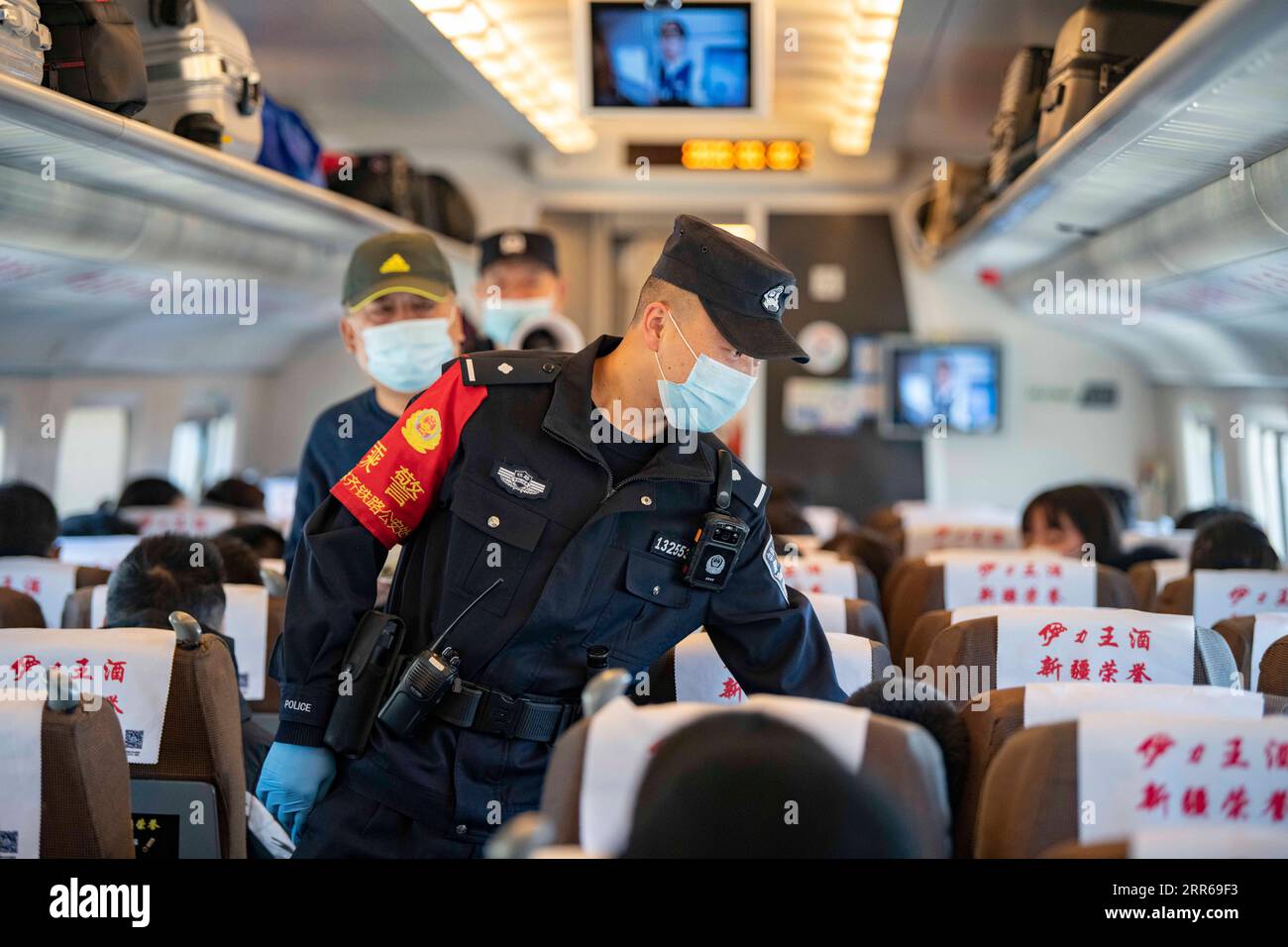 210202 -- URUMQI, 2 febbraio 2021 -- Zhang Jianzhi parla con i passeggeri durante i controlli di sicurezza sul treno D8806 nella regione autonoma di Xinjiang Uygur della Cina nordoccidentale, 30 gennaio 2021. Zhang Jianzhi, un poliziotto ferroviario di 27 anni che lavora a Urumqi, si occupa del suo terzo lavoro di punta per i viaggi del Festival di Primavera. Lavorando per più di 40 giorni consecutivi durante la corsa di viaggi del Festival di Primavera dello scorso anno, Zhang si è sentito dispiaciuto per non essere stato con la sua ragazza Zhao Lelin. Quest'anno, alla fine ha proposto alla sua ragazza sul suo familiare treno D8806. Ho programmato questa proposta speciale sul treno per sorprenderla. Foto Stock