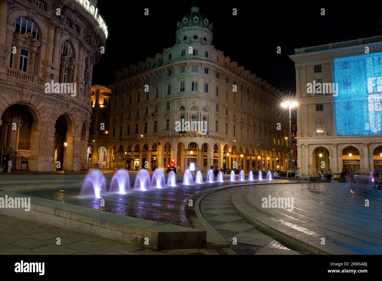 Genova di notte con le fontane più piccole illuminate in viola Foto Stock