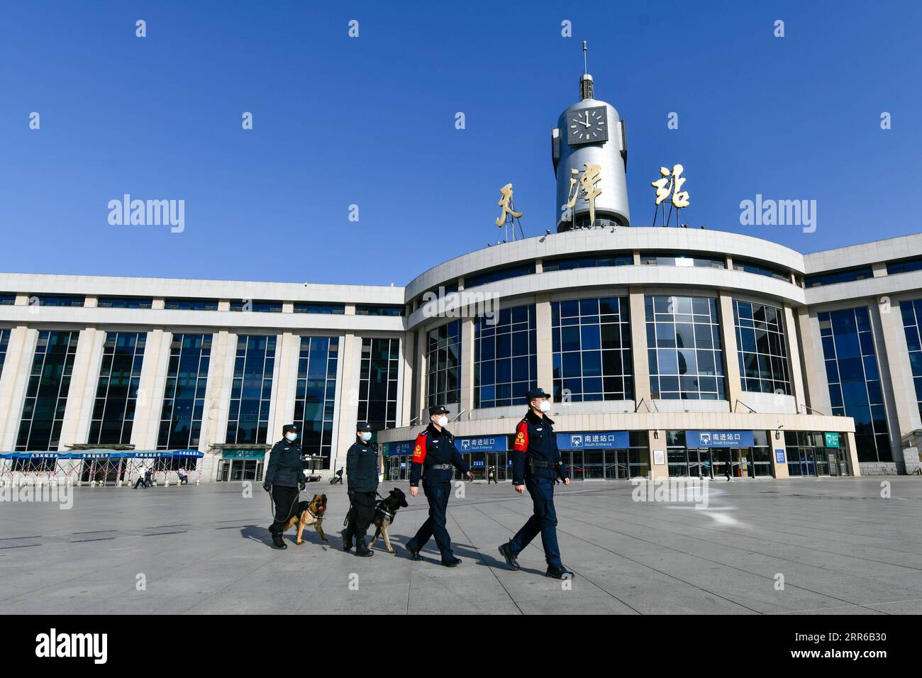 210203 -- TIANJIN, 3 febbraio 2021 -- poliziotti e cani di polizia pattugliano sulla piazza della stazione ferroviaria di Tianjin nel nord della Cina, Tianjin, 1 febbraio 2021. Fen di , un cane ibrido tedesco olandese e anche un cane da guardia presso la filiale di Tianjin dell'ufficio di pubblica sicurezza ferroviaria di Pechino, lavora e vive con il suo allenatore Zhao Hui da tre anni. Ora ci sono una dozzina di cani come Fen di, che agiscono come guardie nella pattuglia di routine e buoni partner nell'addestramento. Durante la corsa di quest'anno al Festival di Primavera, altre pattuglie per Fen di e i suoi compagni di cani sono organizzate presso la ferrovia di Tianjin Foto Stock