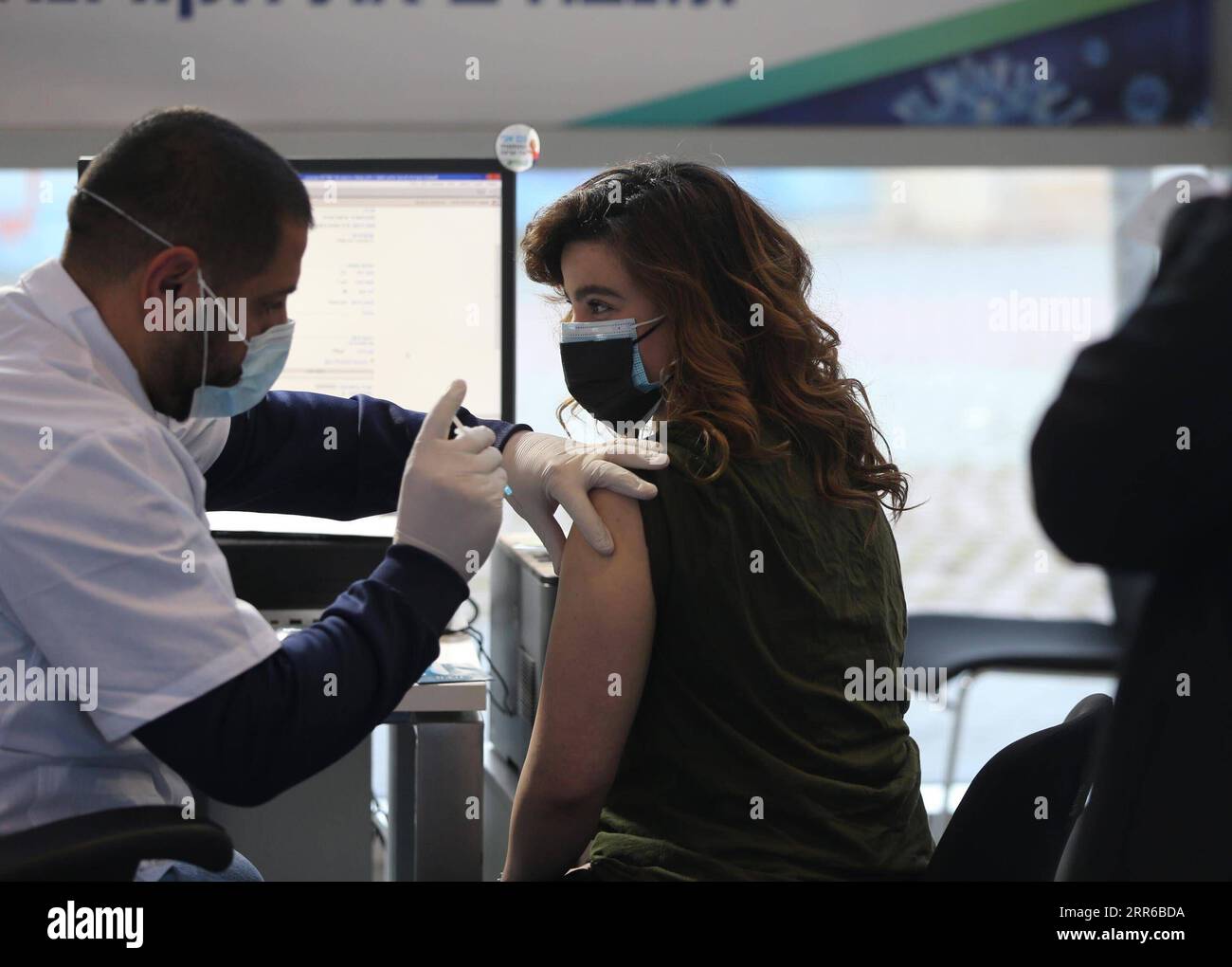 210203 -- GERUSALEMME, 3 febbraio 2021 -- Una donna riceve il vaccino COVID-19 in un centro di assistenza sanitaria a Gerusalemme il 3 febbraio 2021. Israele ha deciso di espandere la campagna di vaccino contro la COVID-19 a tutta la popolazione di età superiore ai 16 anni, a partire da giovedì, ha detto mercoledì il Ministero della salute dello stato. Foto di /Xinhua MIDEAST-GERUSALEMME-COVID-19-CAMPAGNA DI VACCINAZIONE MuammarxAwad PUBLICATIONxNOTxINxCHN Foto Stock