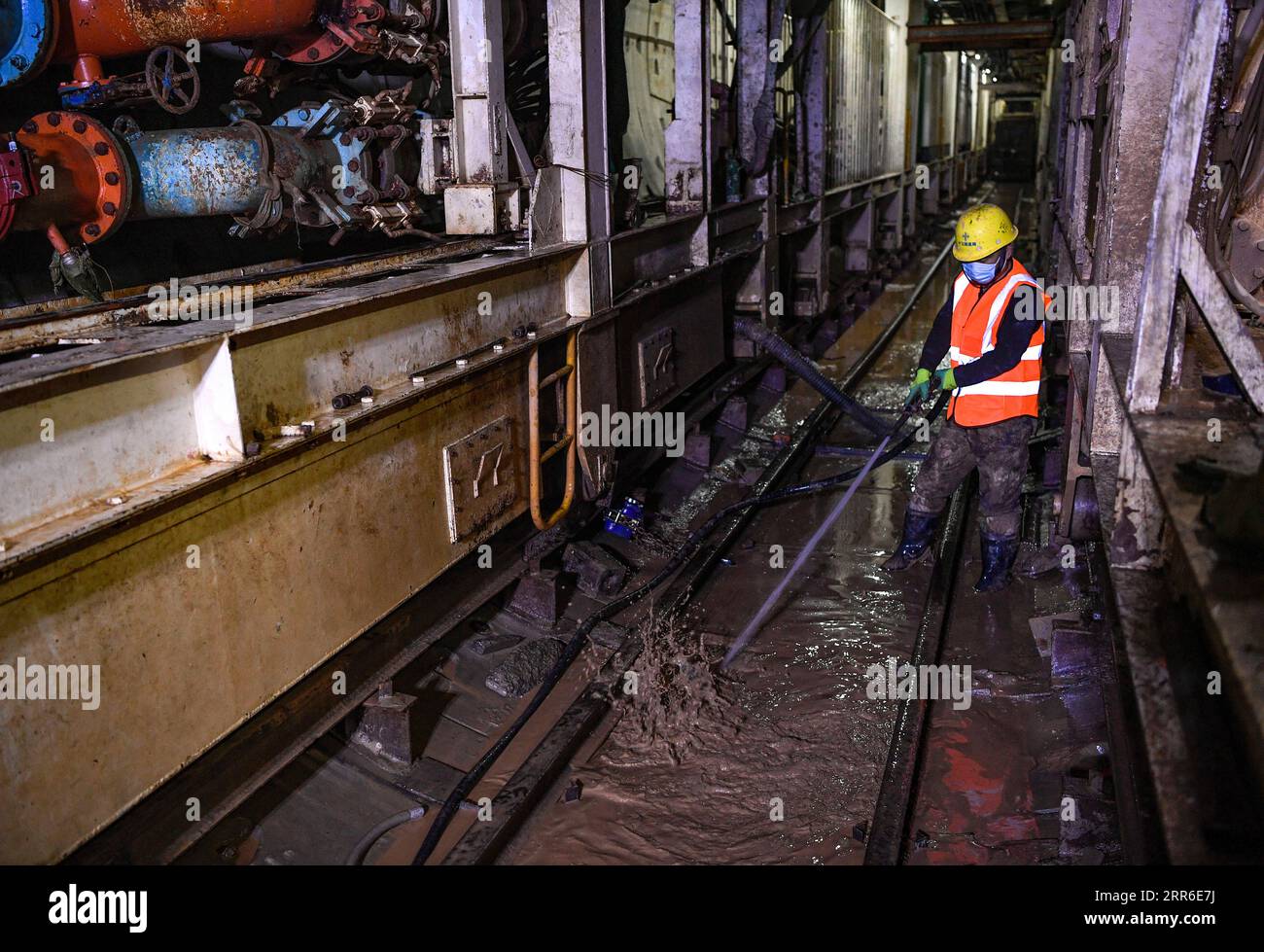 210209 -- ZHONGNING, 9 febbraio 2021 -- Un operaio pulisce i fanghi all'interno di un tunnel attraverso il fiume giallo nella contea di Zhongning, Zhongwei City, nella Cina nordoccidentale, nell'Autonomous Reigon di Ningxia Hui, 9 febbraio 2021. Più di 100 lavoratori sono ancora in servizio nel tunnel per garantire lo sviluppo del progetto in tempo nonostante il prossimo Festival di Primavera o il Capodanno lunare cinese. Questo tunnel, il secondo ad attraversare il fiume giallo a Ningxia, fa parte di un progetto più grande per fornire un servizio di riscaldamento ai residenti a Zhongning. CHINA-NINGXIA-TUNNEL ATTRAVERSO IL FIUME GIALLO CN FENGXKAIHUA PUBLICATIONXNOTXINXCHN Foto Stock