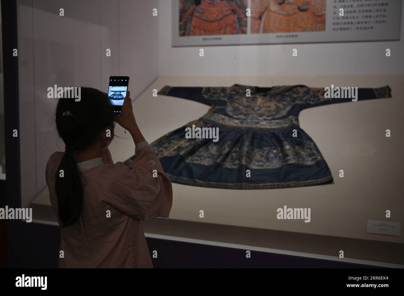 210210 -- PECHINO, 10 febbraio 2021 -- Un visitatore scatta foto durante una mostra con antichi costumi cinesi al Museo Nazionale della Cina, Pechino, capitale della Cina, 10 febbraio 2021. Il Museo Nazionale della Cina ha aperto la sua prima mostra sulla storia generale del costume cinese, portando i visitatori in un viaggio attraverso l'evoluzione dell'antico costume cinese nel corso di migliaia di anni. In mostra ci sono circa 130 pezzi o serie di reliquie culturali, tra cui giada, pietre e ossa, figurine, abbigliamento, accessori in oro e argento, opere di pittura e calligrafia. Gli elementi forniscono un Foto Stock