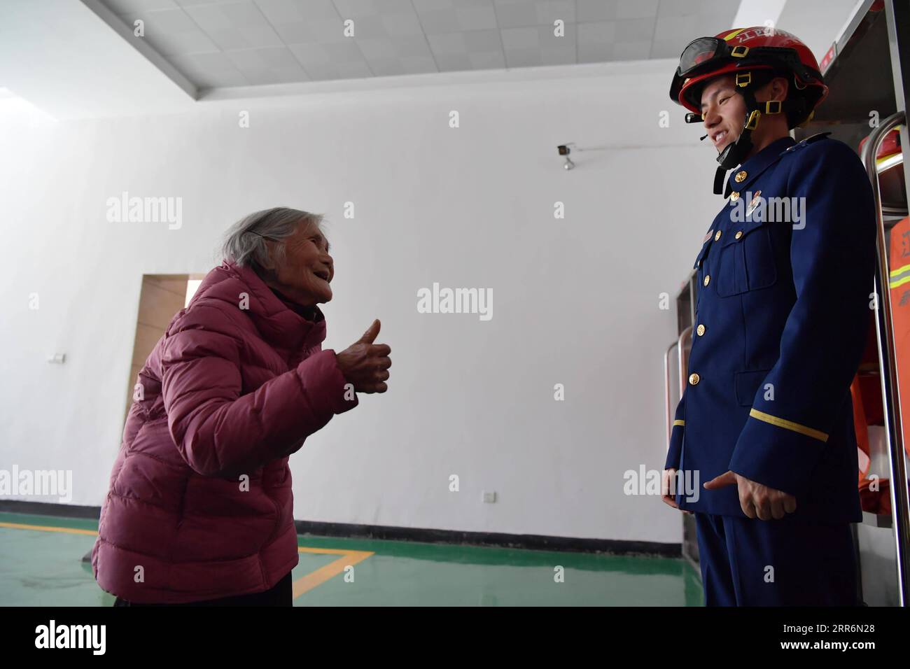 210223 -- NANCHANG, 23 febbraio 2021 -- Zhang Jiagang prende nonna Tang Caiying per visitare il suo luogo di lavoro nella contea di Fenyi, città di Xinyu nella provincia di Jiangxi della Cina orientale, 20 febbraio 2021. Zhang Jiagang, 24 anni, ora vigile del fuoco nella contea di Fenyi della città di Xinyu, è stato trovato abbandonato e adottato 24 anni fa da Tang Caiying, che ora ha 85 anni. Tang Caiying e suo marito crebbero la loro figlia e sei fondatori da soli con stipendi, vendendo verdure e rifiuti. Nel 2001, i vigili del fuoco nella contea di Fenyi iniziarono ad aiutare Tang Caiying e la sua famiglia dopo aver conosciuto la loro esperienza, e.. Foto Stock