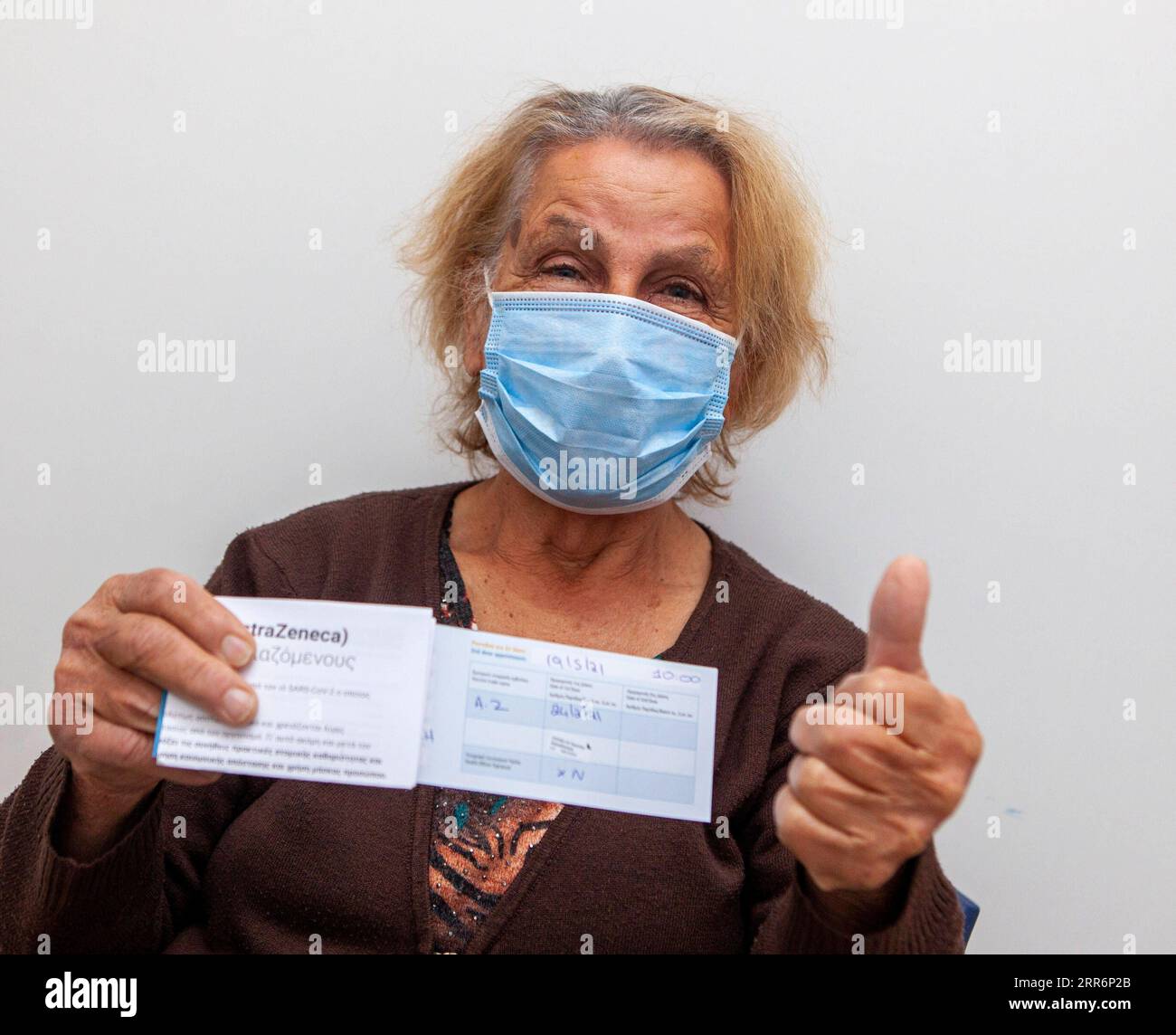 210224 -- NICOSIA, 24 febbraio 2021 -- Una donna mostra il suo certificato di vaccinazione a Nicosia, Cipro, 24 febbraio 2021. La campagna di vaccinazione contro la COVID-19 a Cipro sta aumentando rapidamente, poiché mercoledì dovevano essere consegnate spedizioni di vaccini più grandi nell'ambito del sistema congiunto di approvvigionamento di vaccini dell'Unione europea, ha detto un funzionario del ministero della sanità. Foto di /Xinhua CYPRUS-NICOSIA-COVID-19-VACCINATION GeorgexChristophorou PUBLICATIONxNOTxINxCHN Foto Stock
