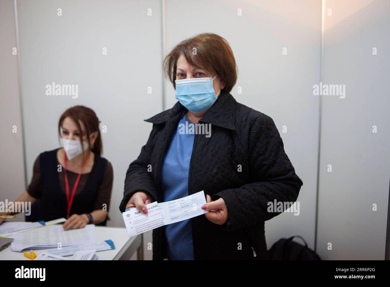 210224 -- NICOSIA, 24 febbraio 2021 -- Una donna mostra il suo certificato di vaccinazione a Nicosia, Cipro, 24 febbraio 2021. La campagna di vaccinazione contro la COVID-19 a Cipro sta aumentando rapidamente, poiché mercoledì dovevano essere consegnate spedizioni di vaccini più grandi nell'ambito del sistema congiunto di approvvigionamento di vaccini dell'Unione europea, ha detto un funzionario del ministero della sanità. Foto di /Xinhua CYPRUS-NICOSIA-COVID-19-VACCINATION GeorgexChristophorou PUBLICATIONxNOTxINxCHN Foto Stock