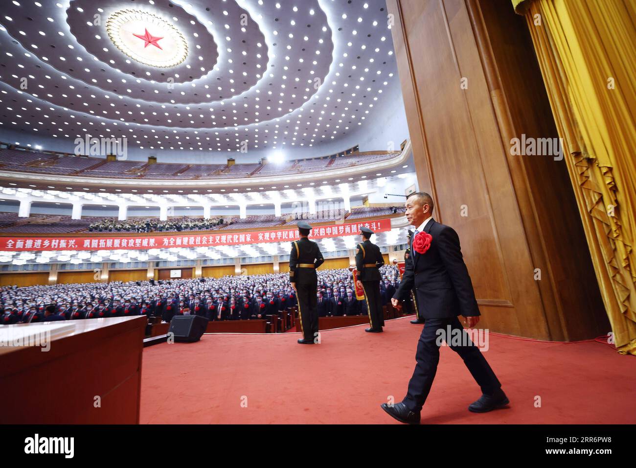 210225 -- PECHINO, 25 febbraio 2021 -- Mao Xianglin, il segretario della sezione del Partito Comunista Cinese del villaggio di Xiazhuang, Zhuxian Township della contea di Wushan, nella Cina sud-occidentale, S Chongqing, va sul palco per ricevere un premio durante un grande raduno per celebrare i risultati ottenuti dalla nazione per alleviare la povertà e onorare i combattenti del modello di povertà presso la grande sala del popolo di Pechino, capitale della Cina, 25 febbraio 2021. CINA-PECHINO-RIDUZIONE DELLA POVERTÀ-GRANDE RADUNO CN JUXPENG PUBLICATIONXNOTXINXCHN Foto Stock