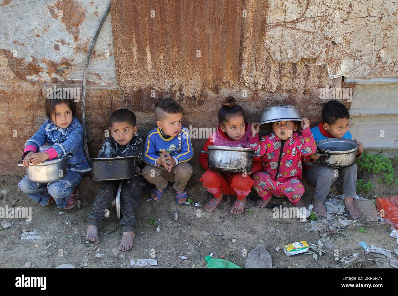 210225 -- GAZA, 25 febbraio 2021 -- i bambini palestinesi aspettano di ricevere pasti di beneficenza nel quartiere di al-Zaitoun, nella parte orientale della città di Gaza, l'8 febbraio 2021. Samira Abu Amra, una donna palestinese del quartiere di al-Zaitoun nella parte orientale della città di Gaza, cucina una grande quantità di cibo due volte alla settimana per le famiglie vicine bisognose. Foto di /Xinhua TO GO WITH Feature: La donna palestinese a Gaza condivide il denaro donato cucinando cibo per i vicini affamati PASTO DI BENEFICENZA DELLA CITTÀ DI MIDEAST-GAZA RizekxAbdeljawad PUBLICATIONxNOTxINxCHN Foto Stock