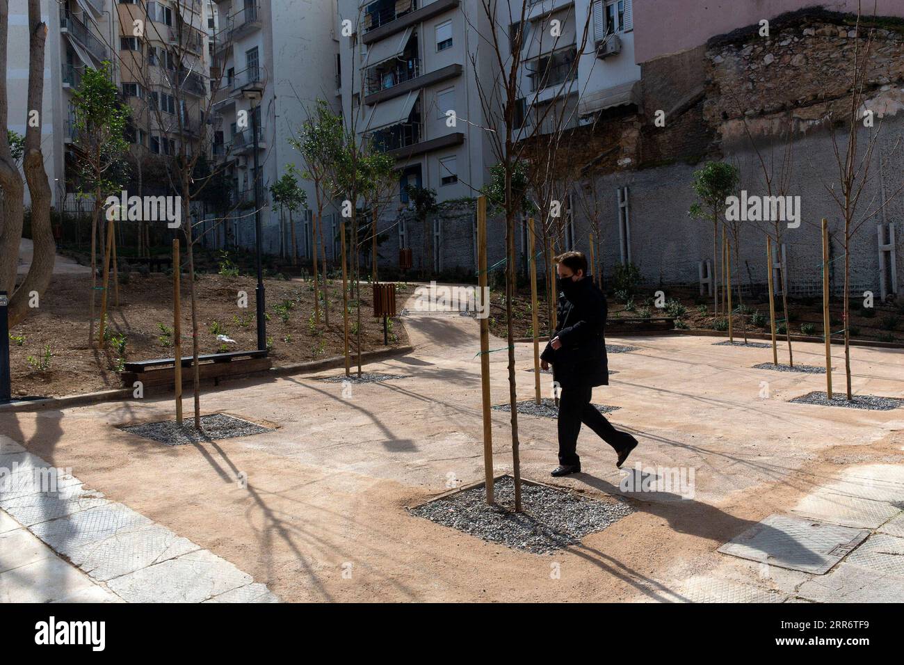 210227 -- ATENE, 27 febbraio 2021 -- Una donna cammina in un parco tascabile nel quartiere Pagrati ad Atene, Grecia, il 25 febbraio 2021. Il parco tascabile, che è stato creato in uno spazio abbandonato che è stato un terreno spazzatura per anni tra blocchi di appartamenti, è il terzo consegnato dalla città di Atene ultimamente, mentre almeno altri dieci sono in fila nei prossimi mesi. Caratteristiche: Parchi tascabili che spuntano ad Atene nell'ambito del nuovo programma GRECIA-ATENE-PARCHI TASCABILI MariosxLolos PUBLICATIONxNOTxINxCHN Foto Stock