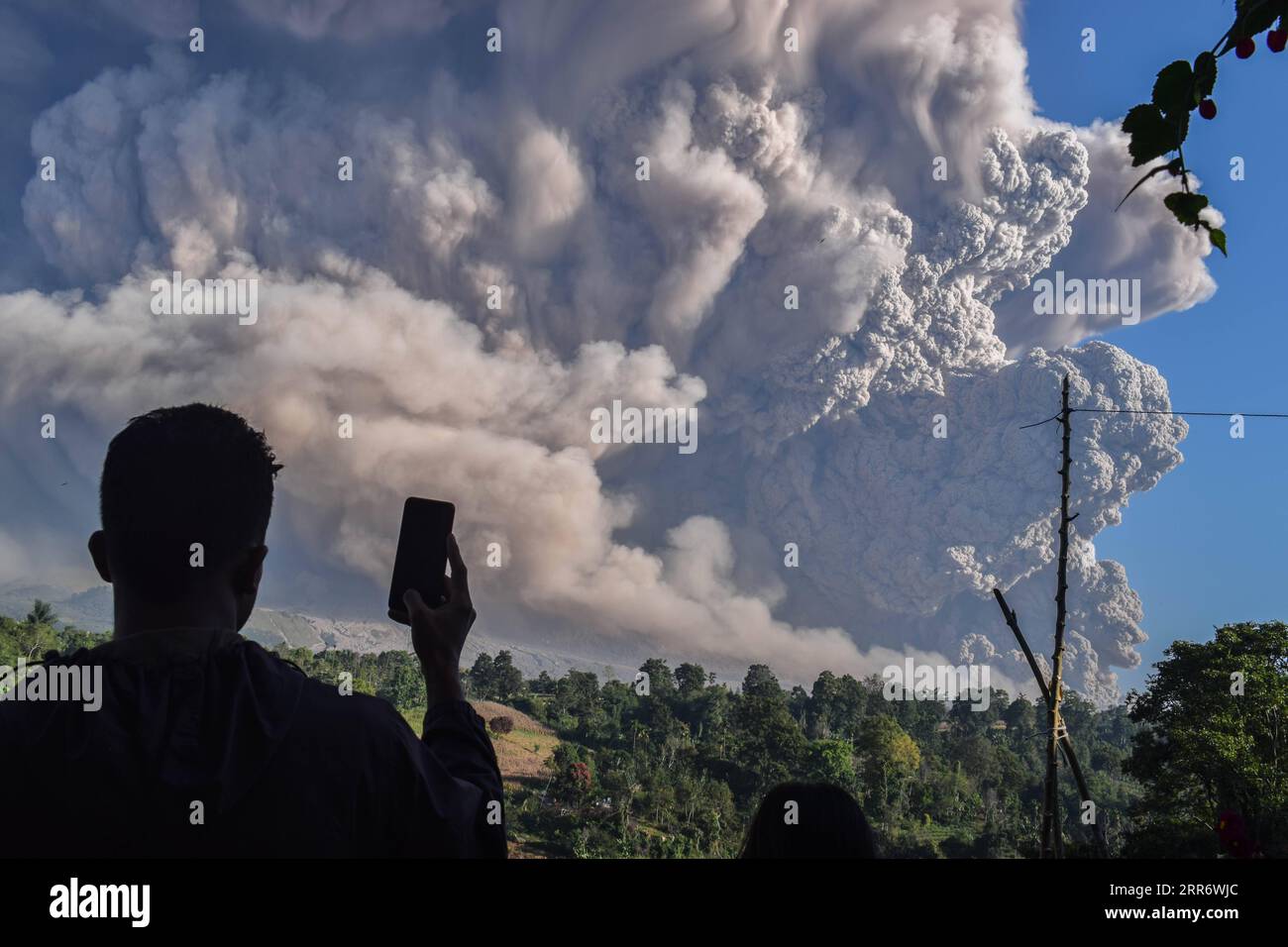 210302 -- NORTH SUMATRA, 2 marzo 2021 -- Un uomo usa il suo cellulare per catturare materiali vulcanici che vengono spediti dal Monte Sinabung a Karo, North Sumatra, Indonesia, 2 marzo 2021. Il Monte Sinabung sull'isola indonesiana di Sumatra eruttò martedì, lanciando nuvole di cenere alte 5.000 metri nel cielo. Non ci sono state notizie di vittime o danni. Foto di /Xinhua INDONESIA-NORD SUMATRA-MOUNT SINABUNG-ERUPTION SariantoxSembiring PUBLICATIONxNOTxINxCHN Foto Stock