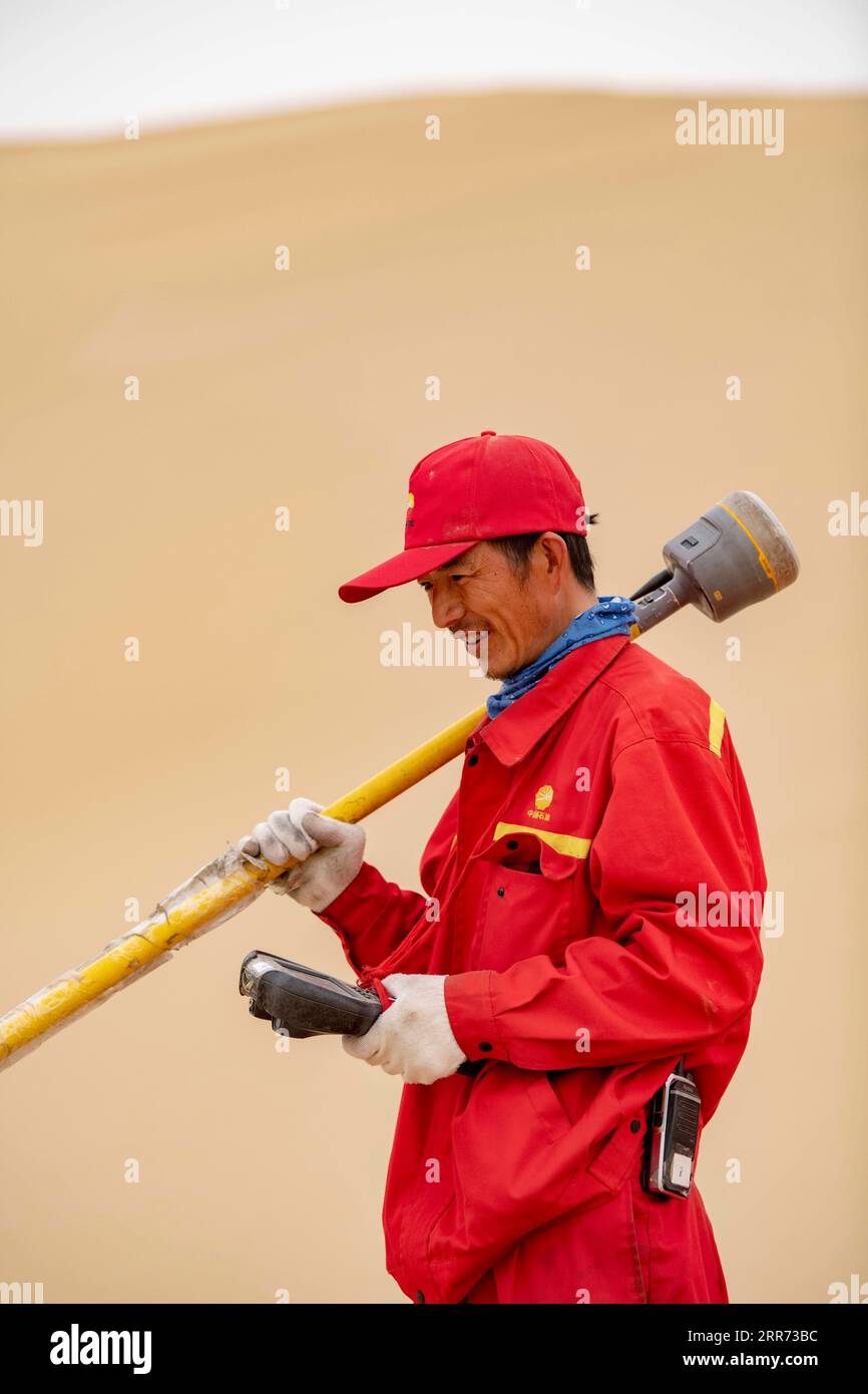 210310 --URUMQI, 10 marzo 2021 -- Feng Yongsheng del team geofisico di indagine lavora nel deserto di Taklimakan, regione autonoma di Xinjiang Uygur della Cina nordoccidentale, 25 febbraio 2021. Il deserto di Taklimakan, situato nel bacino del Tarim, nella regione autonoma di Xinjiang Uygur della Cina nord-occidentale, è una delle principali regioni petrolifere della Cina e una delle più difficili da esplorare a causa del suo ambiente duro e delle complicate condizioni sotterranee. Per esplorare le risorse di petrolio e gas sono necessari più processi, tra cui lo svolgimento di indagini geofisiche, in modo da raccogliere dati sismici per gettare solide basi Foto Stock