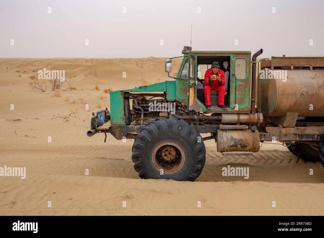 210310 --URUMQI, 10 marzo 2021 -- Un lavoratore del team di indagine geofisica pranza nel deserto di Taklimakan, regione autonoma di Xinjiang Uygur, nella Cina nordoccidentale, 25 febbraio 2021. Il deserto di Taklimakan, situato nel bacino del Tarim, nella regione autonoma di Xinjiang Uygur della Cina nord-occidentale, è una delle principali regioni petrolifere della Cina e una delle più difficili da esplorare a causa del suo ambiente duro e delle complicate condizioni sotterranee. Per esplorare le risorse di petrolio e gas sono necessari più processi, tra cui lo svolgimento di indagini geofisiche, in modo da raccogliere dati sismici per gettare solide basi f Foto Stock