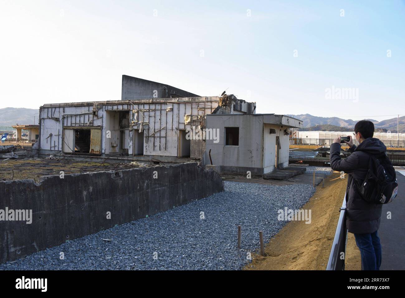 210311 -- ISHINOMAKI, 11 marzo 2021 -- Un visitatore scatta una foto delle rovine della Okawa Elementary School a Ishinomaki, Giappone, 9 marzo 2021. Una scuola elementare pubblica nella prefettura di Miyagi ha perso più di 80 vite nello tsunami a seguito del terremoto del marzo 2011 nel Giappone nordorientale. Dieci anni dopo, le rovine dell'edificio scolastico raccontano ancora l'inimmaginabile tragedia della calamità. A PARTIRE DA 10 anni, la scuola giapponese di tsunami-hit racconta ancora una tragedia inimmaginabile JAPAN-ISHINOMAKI-TSUNAMI-ANNIVERSARIO-ELEMENTARE SCUOLA GangxYe PUBLICATIONxNOTxINxCHN Foto Stock