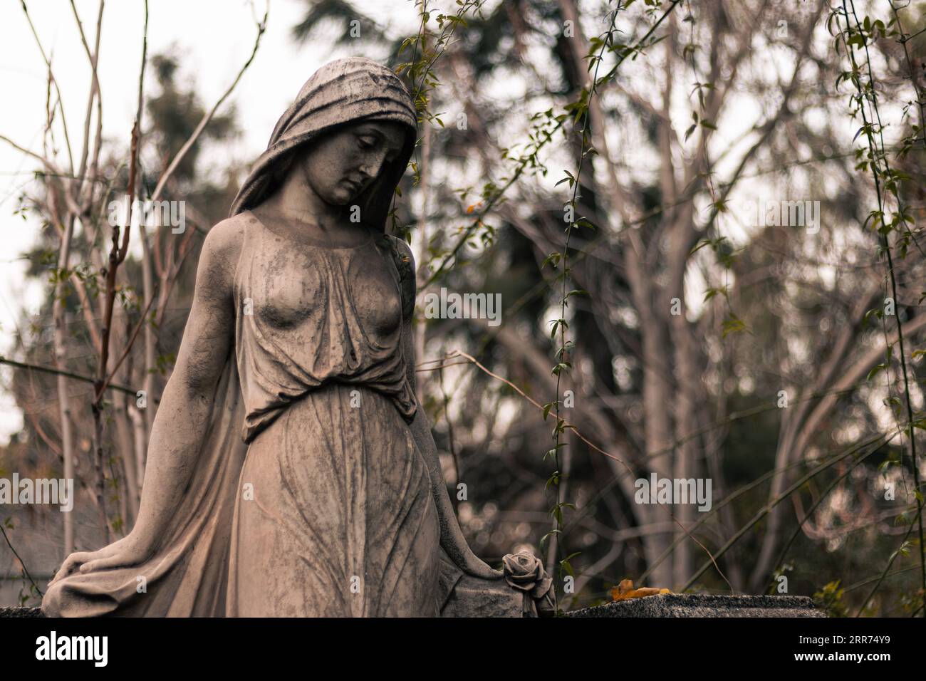 statua religiosa di donna malinconica che pensa in un cimitero all'aperto Foto Stock