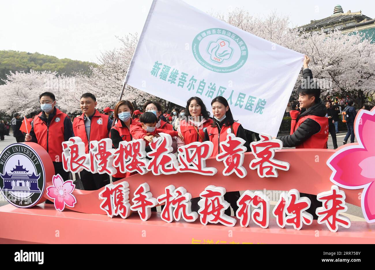 210313 -- WUHAN, 13 marzo 2021 -- i medici della regione autonoma di Xinjiang Uygur posano per una foto all'Università di Wuhan a Wuhan, provincia di Hubei, Cina centrale, 13 marzo 2021. Wuhan University, uno dei posti migliori della città per festeggiare gli occhi degli ammiratori della fioritura dei ciliegi, ha annunciato che offrirà tour e spettacoli esclusivi gratuiti per gli operatori sanitari in tutta la Cina che avevano assistito Wuhan nella lotta contro l'epidemia nel 2020 e i loro parenti da sabato a domenica. CHINA-HUBEI-WUHAN UNIVERSITY-CHERRY BLOSSOMS-MEDICAL WORKER CN CHENGXMIN PUBLICATIONXNOTXINXCHN Foto Stock