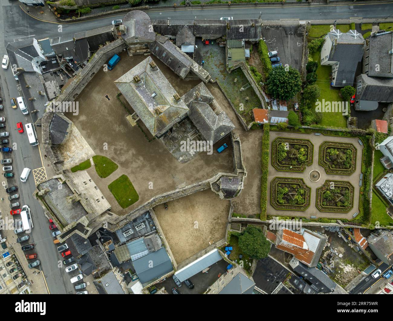 Vista aerea del castello di Roscrea e della città nell'Irlanda centrale con casa a torre che racchiude mura con torre circolare e giardino Foto Stock