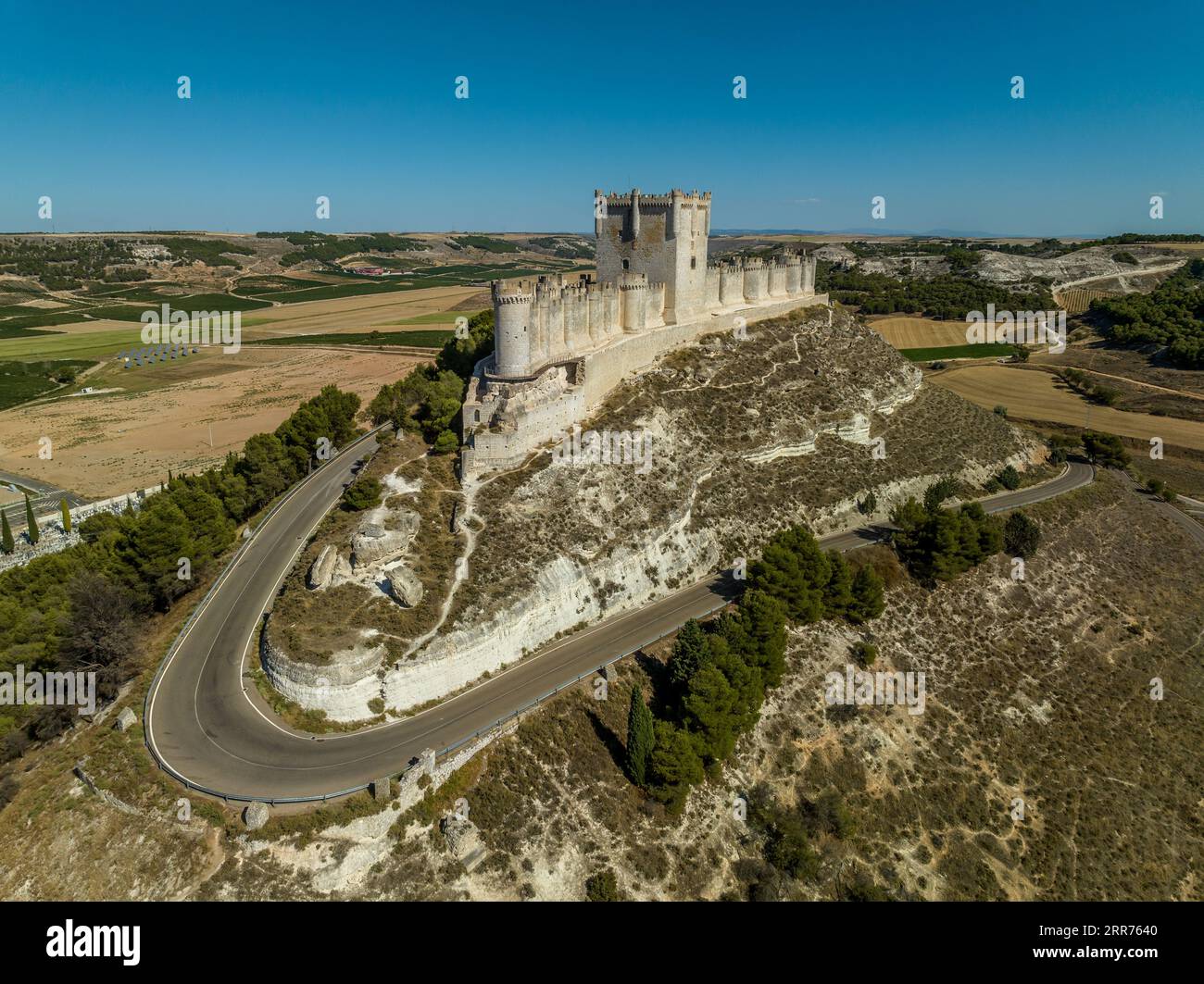 Vista panoramica aerea del castello di Penafiel in Spagna, con lo sfondo blu del cielo, le lunghe mura racchiudono la cima della collina, il castello a tre piani e le torrette Foto Stock