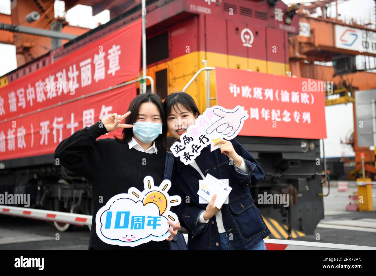 210319 -- CHONGQING, 19 marzo 2021 -- gli ospiti posano per una foto davanti a un treno merci Yuxin ou Chongqing-Xinjiang-Europe China-Europe prima che lasci la stazione del villaggio di Tuanjie nel comune di Chongqing della Cina sud-occidentale, 19 marzo 2021. Con un forte fischio che riecheggia attraverso l'aria, un treno merci diretto a Duisburg, in Germania, è lentamente uscito dalla stazione del villaggio di Tuanjie nel comune di Chongqing della Cina sud-occidentale il venerdì mattina. Esattamente dieci anni fa, ho segnalato al primo treno merci Cina-Europa, lo Yuxin ou Chongqing-Xinjiang-Europe, di partire da qui, Zhang Xin Re Foto Stock