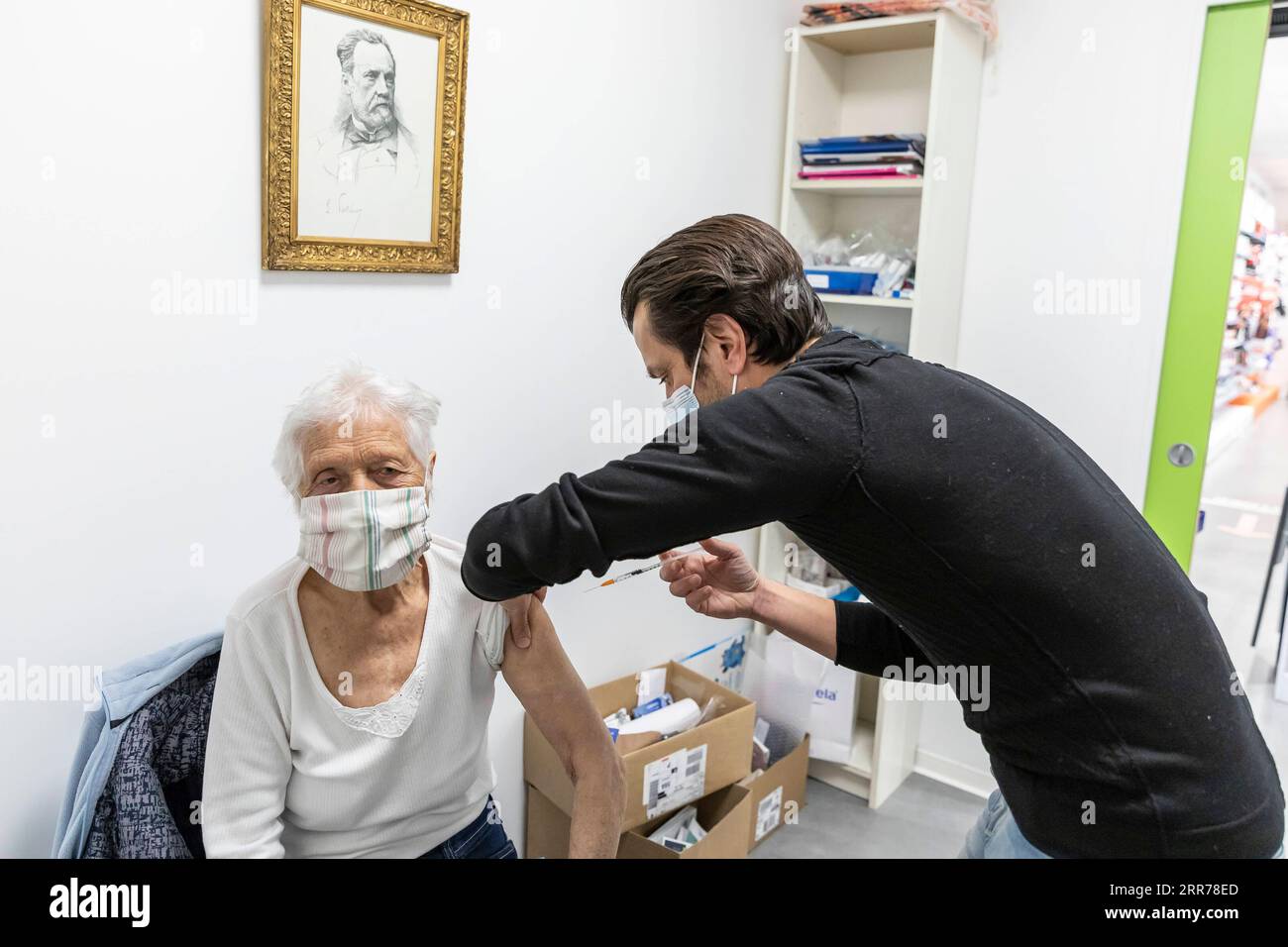 210319 -- TOURCOING FRANCIA, 19 marzo 2021 -- Un farmacista amministra il vaccino AstraZeneca COVID-19 a una donna in una farmacia a Tourcoing, Hauts-de-France, Francia, il 19 marzo 2021. La Francia ha ripreso il lancio del vaccino AstraZeneca COVID-19 venerdì. La Francia è stato uno dei molti paesi europei che avevano sospeso l'introduzione del vaccino Oxford/AstraZeneca all'inizio di questa settimana, citando preoccupazioni per le segnalazioni di persone che sviluppano coaguli di sangue dopo il jab. Foto di /Xinhua FRANCE-TOURCOING-COVID-19 VACCINE-ASTRAZENECA-RESUMPTION SebastienxCourdji PUBLICATIONxNOTxINxCHN Foto Stock