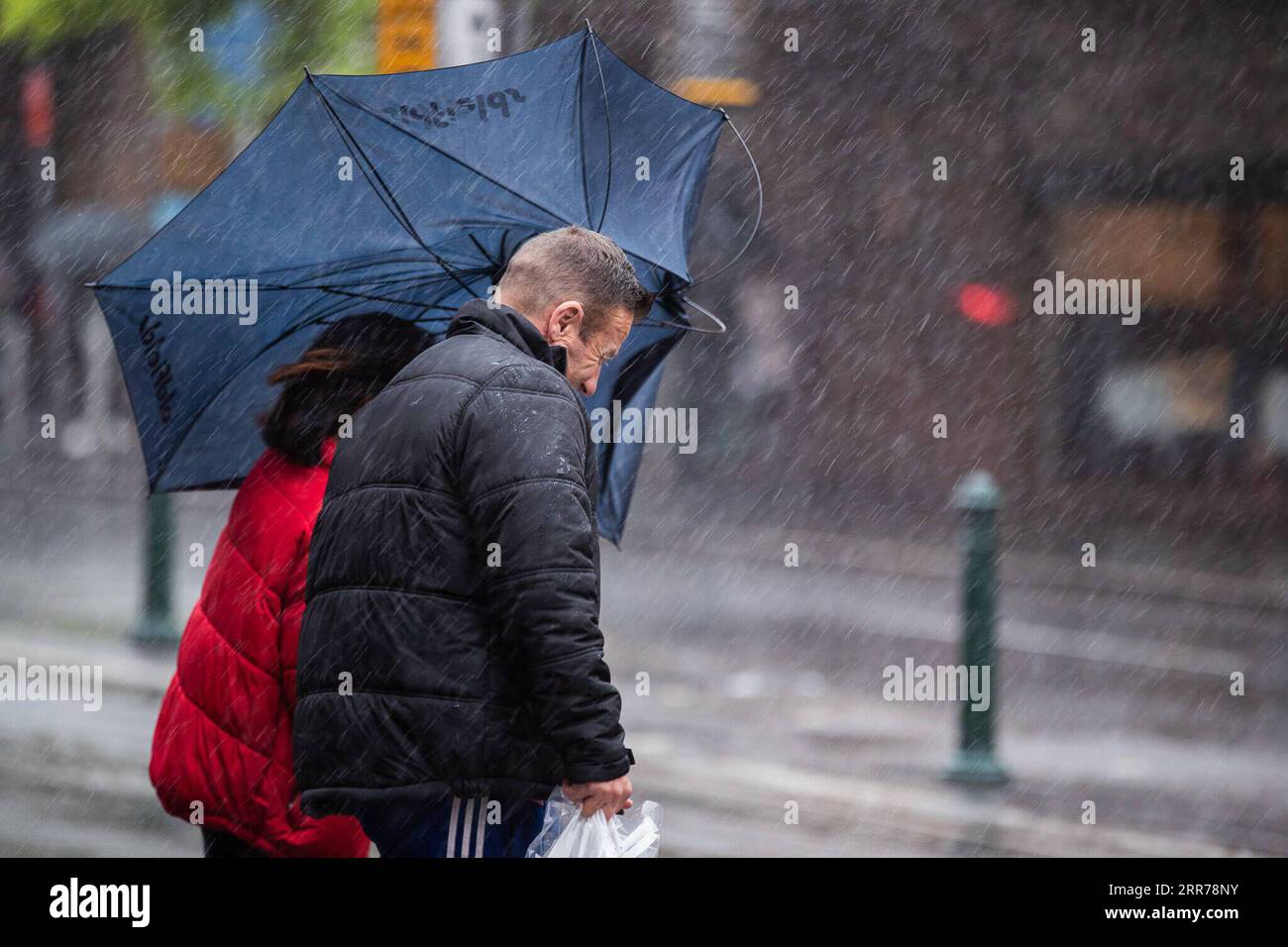 210320 -- SYDNEY, 20 marzo 2021 -- la gente cammina sotto la pioggia a Sydney, Australia, 20 marzo 2021. Lo stato più popoloso dell'Australia, il New South Wales, è stato caratterizzato da condizioni meteorologiche estreme, poiché le precipitazioni record stanno innescando sponde del fiume, fuoriuscite di dighe, blocchi stradali ed evacuazioni. Foto di /Xinhua AUSTRALIA-SYDNEY-FORTI PIOGGE HuxJingchen PUBLICATIONxNOTxINxCHN Foto Stock