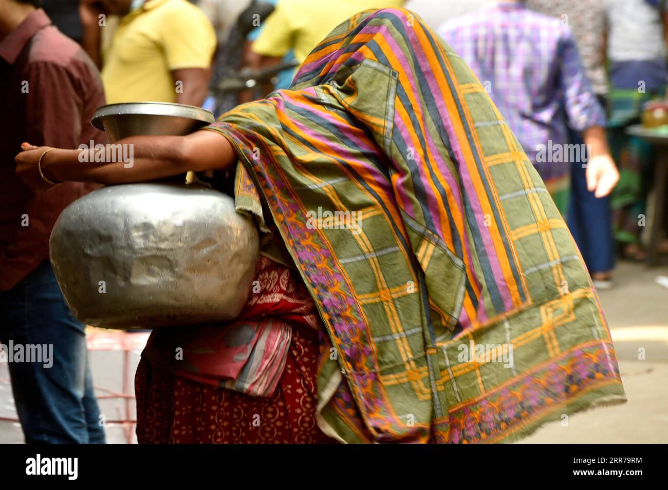 210322 -- DACCA, 22 marzo 2021 -- Una donna porta con sé una caraffa d'acqua raccolta da un pozzo tubolare a Dacca, Bangladesh, il 22 marzo 2021. La scarsità d'acqua è un problema in alcune parti di Dacca. Per gli abitanti delle baraccopoli, la scarsità d'acqua continua ad essere una delle principali preoccupazioni ogni anno. BANGLADESH-DHAKA-WATER-SCARCITY Salim PUBLICATIONxNOTxINxCHN Foto Stock