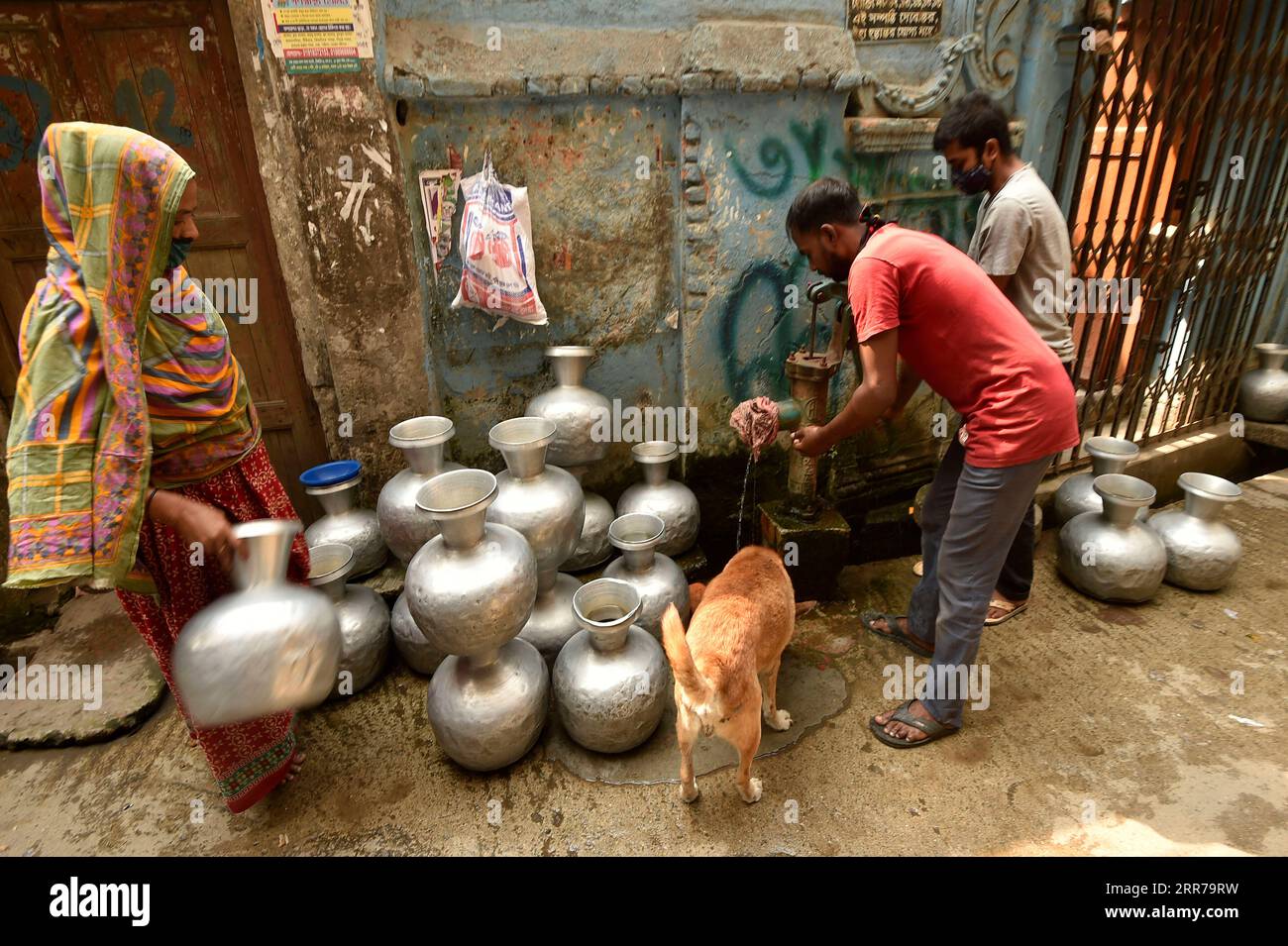 210322 -- DACCA, 22 marzo 2021 -- la gente raccoglie acqua da un pozzo di un tubo a Dacca, Bangladesh, il 22 marzo 2021. La scarsità d'acqua è un problema in alcune parti di Dacca. Per gli abitanti delle baraccopoli, la scarsità d'acqua continua ad essere una delle principali preoccupazioni ogni anno. BANGLADESH-DHAKA-WATER-SCARCITY Salim PUBLICATIONxNOTxINxCHN Foto Stock