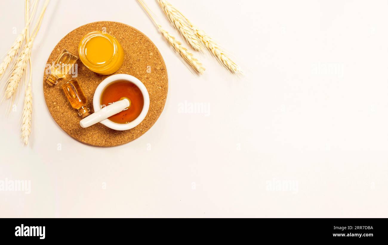Olio essenziale miele sughero marrone con orecchie di grano su sfondo bianco Foto Stock