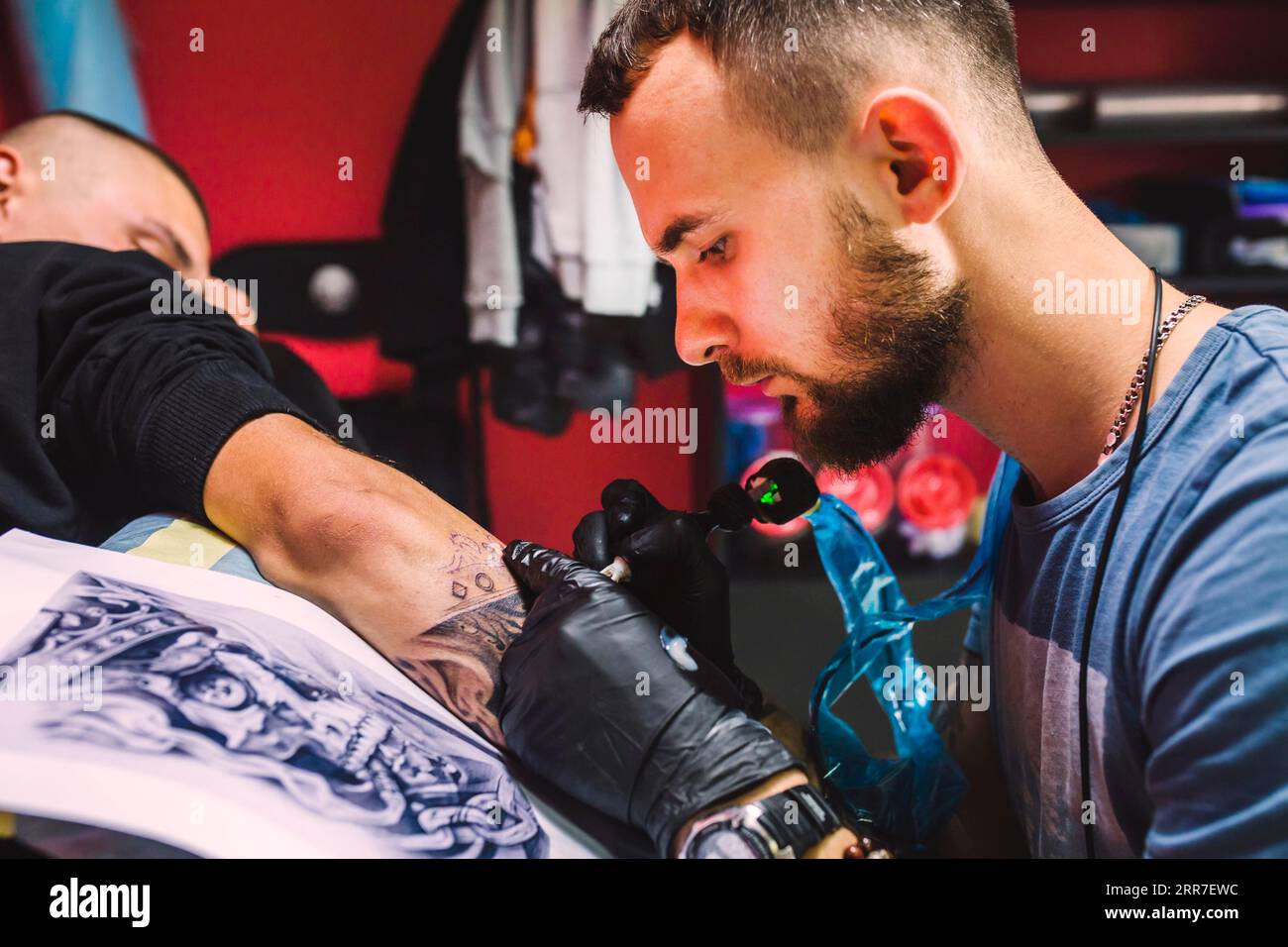 Uomo adulto che lavora con il braccio della penna per tatuaggi Foto stock -  Alamy