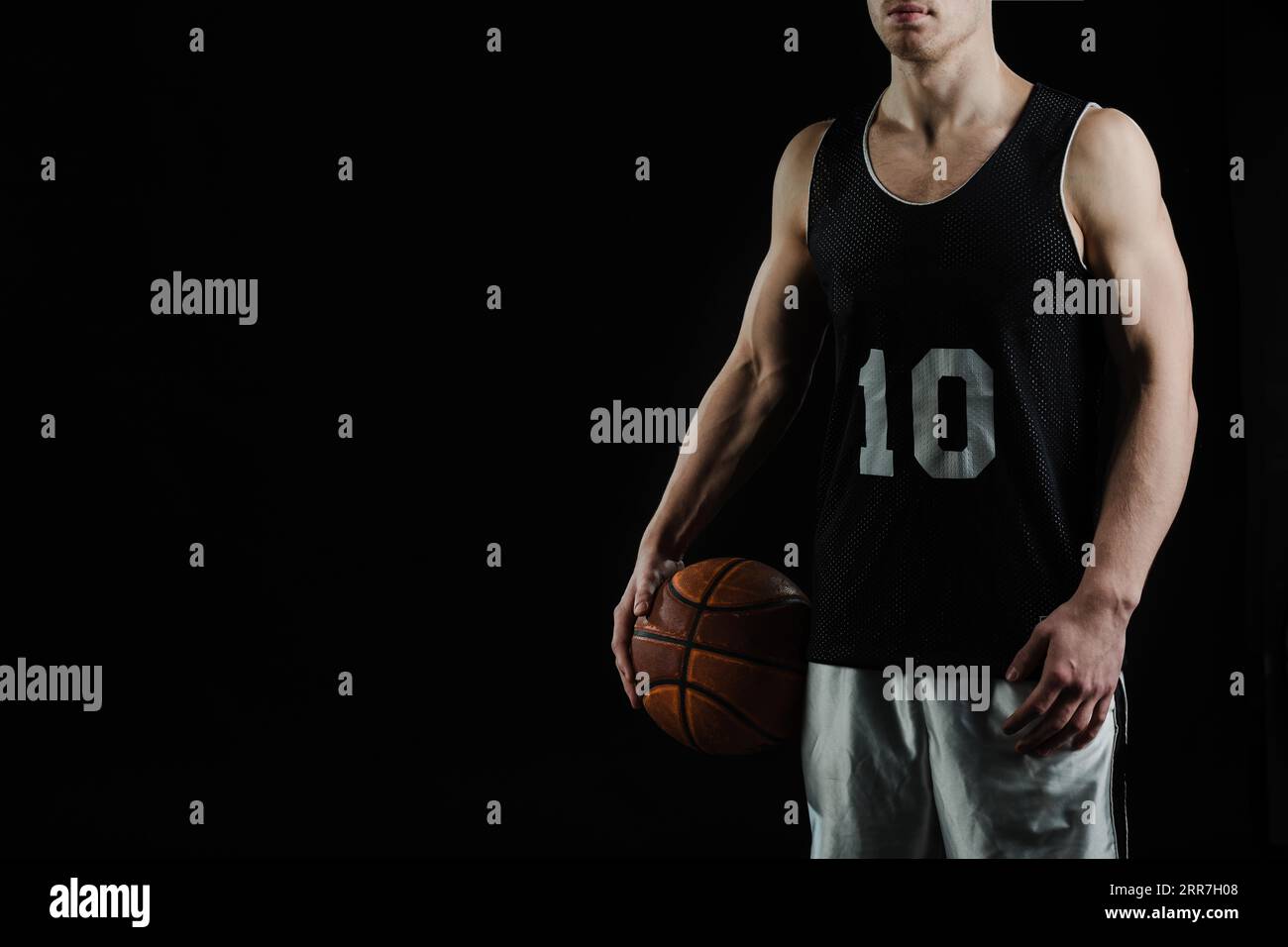 Giocatore professionista di basket che tiene la palla al braccio Foto Stock