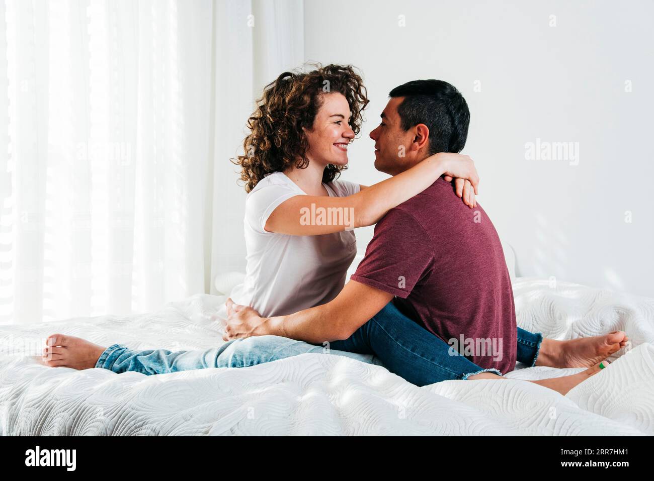 Giovane uomo che abbraccia il letto di una donna felice Foto Stock