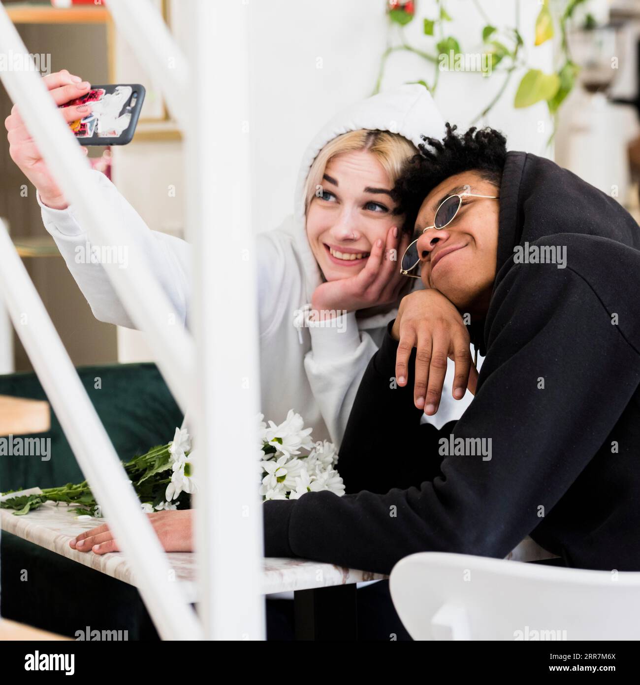 Giovane coppia adolescente simpatica e interrazziale che scatta selfie sul cellulare Foto Stock