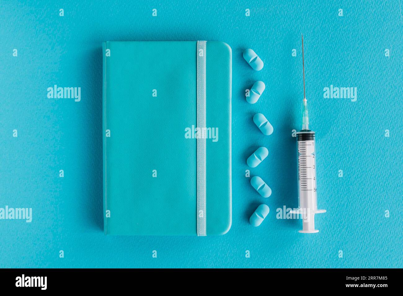Diario pillole siringa superficie blu Foto Stock