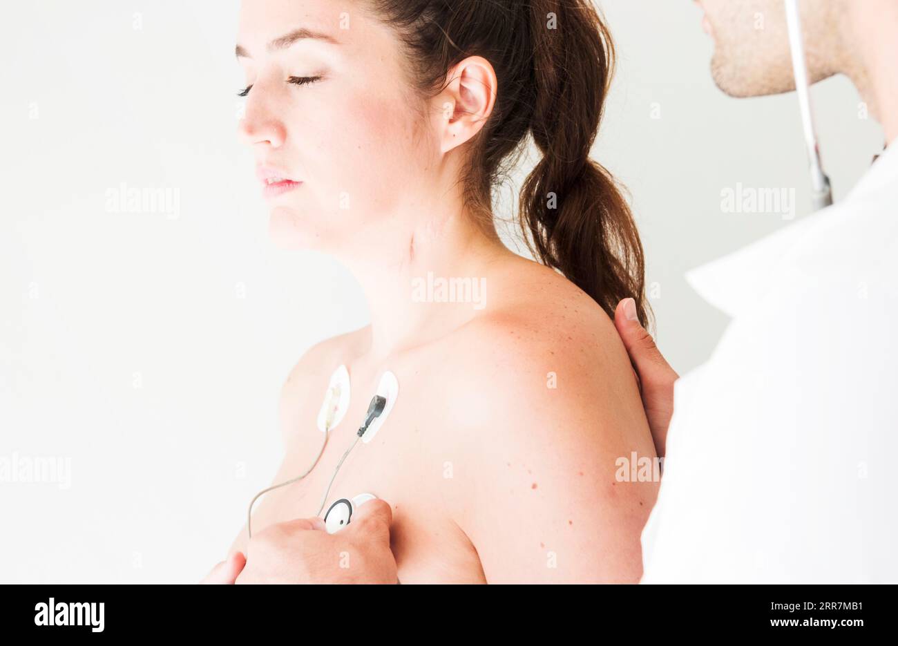 Medico con stetoscopio che controlla la respirazione signora Foto Stock