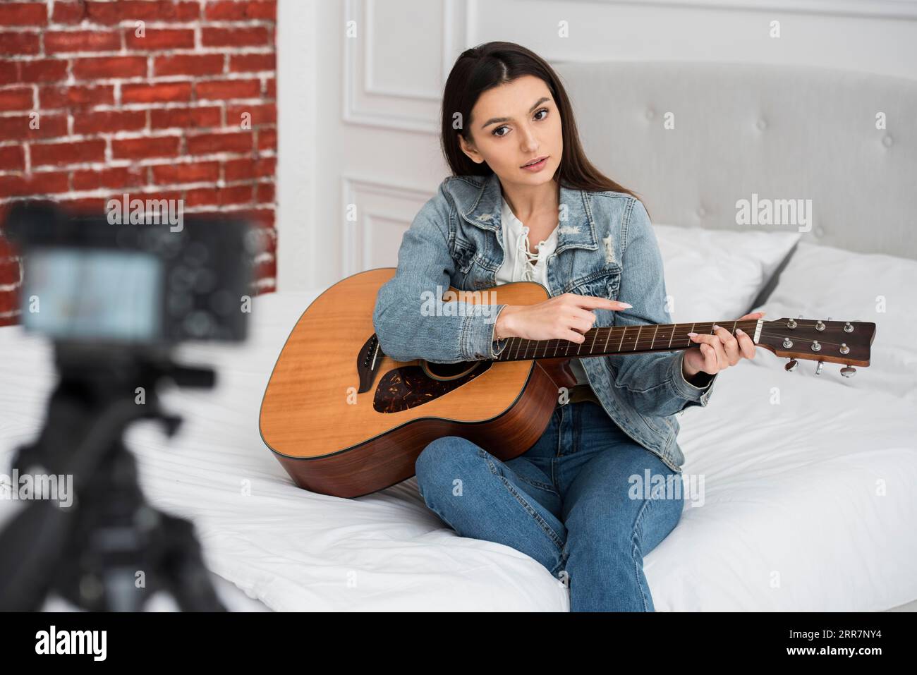 Giovane blogger che insegna come suonare la chitarra Foto Stock