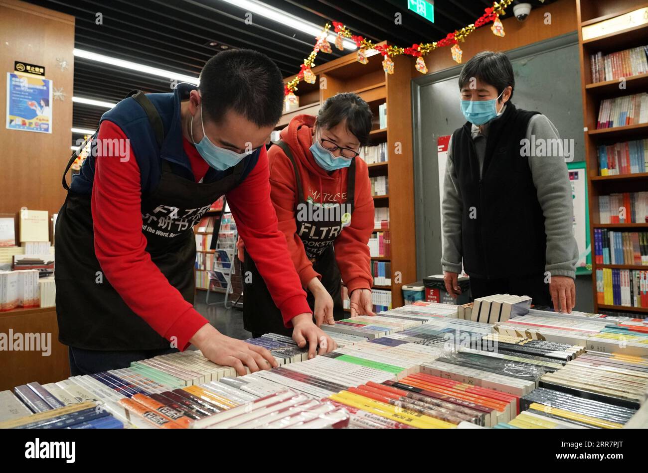 210402 -- PECHINO, 2 aprile 2021 -- Kang Rui 1st L organizza libri con il suo collega C alla Foreign Language Teaching and Research Press FLTRP Bookstore di Pechino, capitale della Cina, 25 marzo 2021. Kang Rui, 22 anni, è un poster designer di Foreign Language Teaching and Research Press FLTRP Bookstore a Pechino. Diagnosticato autismo all'età di cinque anni e mezzo, Kang Rui fu mandato a studiare in un centro di istruzione speciale per bambini autistici, dove fece grandi progressi nelle capacità di apprendimento e nelle capacità di vita. Con l'azienda della sua famiglia, Kang terminò il liceo professionale e mostrò il talento Foto Stock