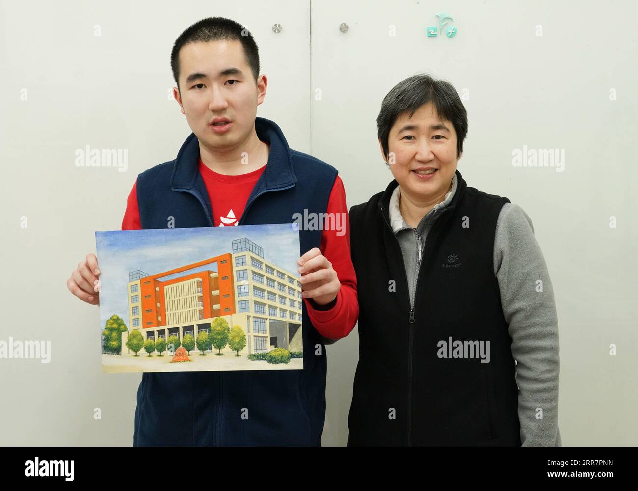 210402 -- PECHINO, 2 aprile 2021 -- Kang Rui L mostra un poster che ha disegnato al Foreign Language Teaching and Research Press FLTRP Bookstore di Pechino, capitale della Cina, 25 marzo 2021. Kang Rui, 22 anni, è un poster designer di Foreign Language Teaching and Research Press FLTRP Bookstore a Pechino. Diagnosticato autismo all'età di cinque anni e mezzo, Kang Rui fu mandato a studiare in un centro di istruzione speciale per bambini autistici, dove fece grandi progressi nelle capacità di apprendimento e nelle capacità di vita. Con l'azienda della sua famiglia, Kang terminò il liceo professionale e mostrò talento nel disegno e. Foto Stock