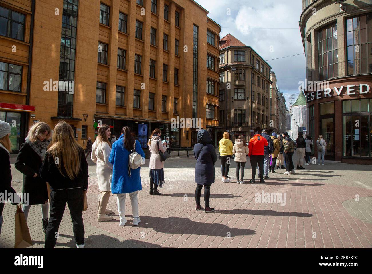 210407 -- RIGA, 7 aprile 2021 -- le persone si mettono in fila per entrare in un negozio a riga, Lettonia, il 7 aprile 2021. Poiché lo stato di emergenza, in vigore dal 9 novembre 2020, si è concluso mercoledì, i rivenditori lettoni si sono affrettati a riaprire i loro negozi agli acquirenti. Durante lo stato di emergenza, solo gli alimentari e i rivenditori al dettaglio che vendono beni essenziali potrebbero rimanere aperti. Foto di /Xinhua LETTONIA-RIGA-COVID-19-STATO DI FINE EMERGENZA EdijsxPalens PUBLICATIONxNOTxINxCHN Foto Stock