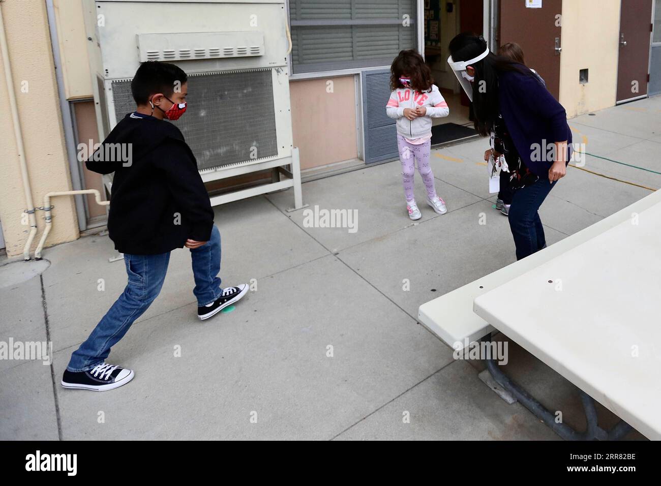 210413 -- LOS ANGELES, 13 aprile 2021 -- gli studenti suonano in una scuola a Los Angeles, California, Stati Uniti, il 13 aprile 2021. Dall'inizio della pandemia di COVID-19 per la prima volta in più di un anno, alcune scuole di Los Angeles hanno riaperto per le lezioni di persona martedì. Gli standard di sicurezza e i test obbligatori per la COVID-19 degli studenti erano in vigore, ma molti genitori hanno ancora optato per mantenere i loro figli ad imparare da casa. U.S.-LOS ANGELES-COVID-19-SCHOOLS-REOPEN XINHUA PUBLICATIONXNOTXINXCHN Foto Stock