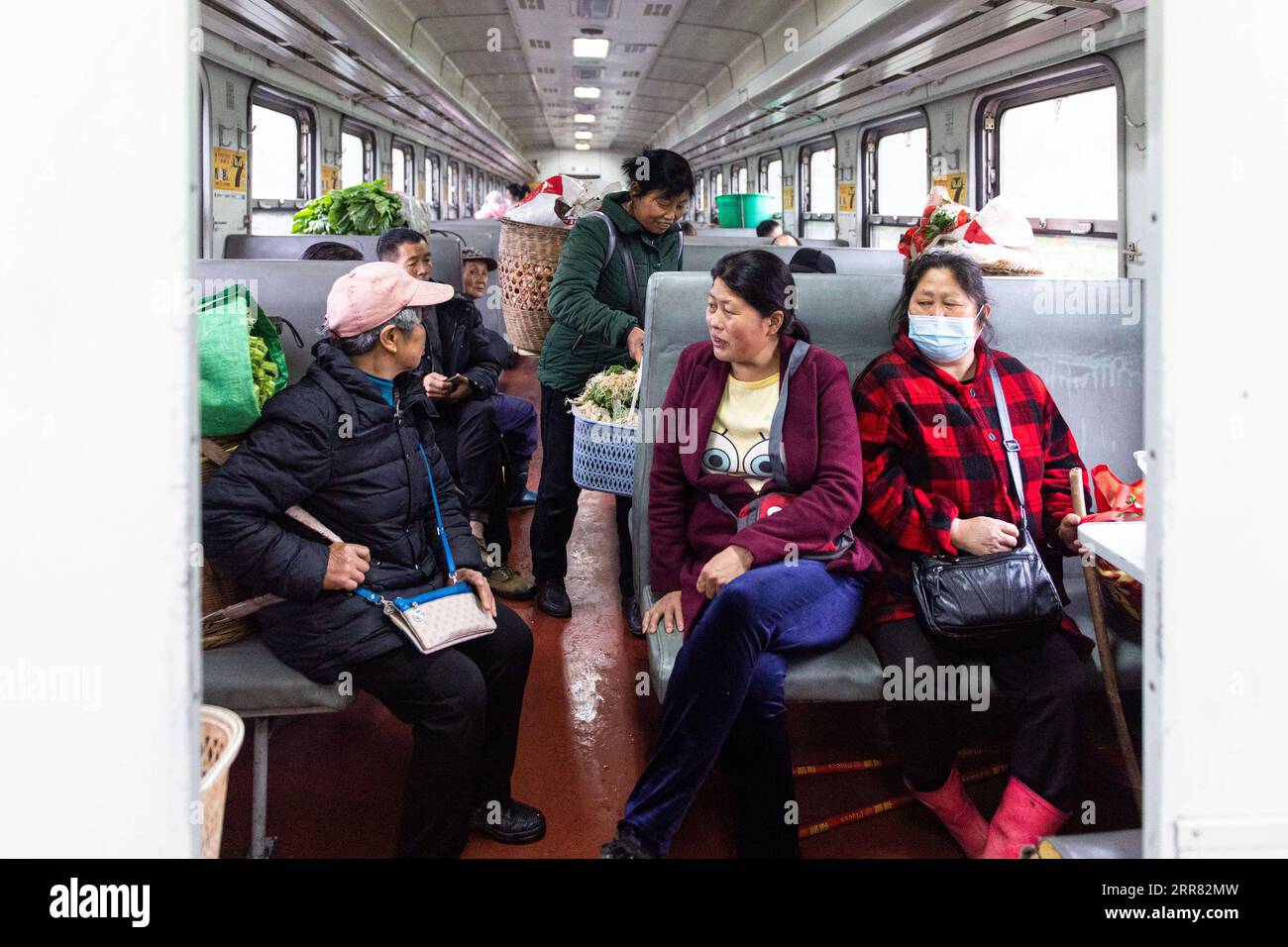 210414 -- CHANGSHA, 14 aprile 2021 -- i passeggeri parlano sul treno 7266 nella provincia centrale di Hunan della Cina, 11 aprile 2021. I treni 7265/7266/7267 iniziarono a funzionare nel 1995, estendendosi per più di 300 chilometri dalla stazione di Huaihua alla stazione di Lixian. I treni passano 37 fermate lungo il tragitto in 9 ore e 16 minuti. I prezzi dei biglietti variano da 1 yuan a 23,5 yuanabout 0,15-3,59 dollari americani, che non sono stati aumentati in 26 anni. I treni attraversano le Wuling Mountains. Grazie a loro, gli abitanti del villaggio non solo possono portare in vendita frutta, verdura e altri prodotti locali, ma anche me Foto Stock