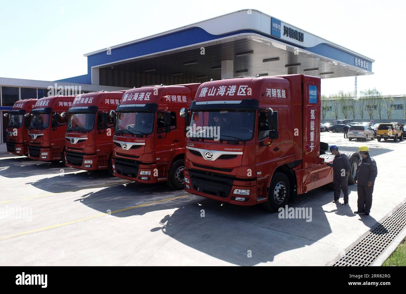 210414 -- TANGSHAN, 14 aprile 2021 -- la foto scattata con un drone mostra i lavoratori che esaminano cinque camion pesanti alimentati a idrogeno di recente introduzione nella zona di sviluppo economico di Tangshan Haigang a Tangshan, nella provincia di Hebei nella Cina settentrionale, 14 aprile 2021. Mercoledì sono stati introdotti cinque camion pesanti alimentati a idrogeno dalla zona di sviluppo economico di Tangshan Haigang. La flotta di veicoli industriali è tra i primi tentativi della zona di ottimizzare la struttura industriale e il consumo energetico sostituendo gradualmente il carburante diesel con le celle di alimentazione a idrogeno più ecologiche. CINA-HEBEI-TANGSHAN- Foto Stock