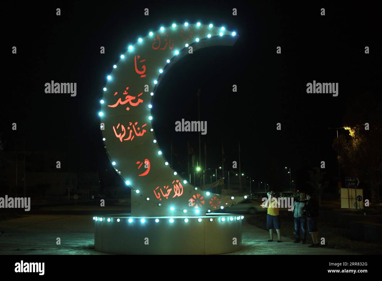 210414 -- AMMAN, 14 aprile 2021 -- la gente si trova accanto a una decorazione Ramadan durante il mese sacro islamico del Ramadan ad Amman, Giordania, il 14 aprile 2021. Foto di /Xinhua JORDAN-AMMAN-RAMADAN MohammadxAbuxGhosh PUBLICATIONxNOTxINxCHN Foto Stock